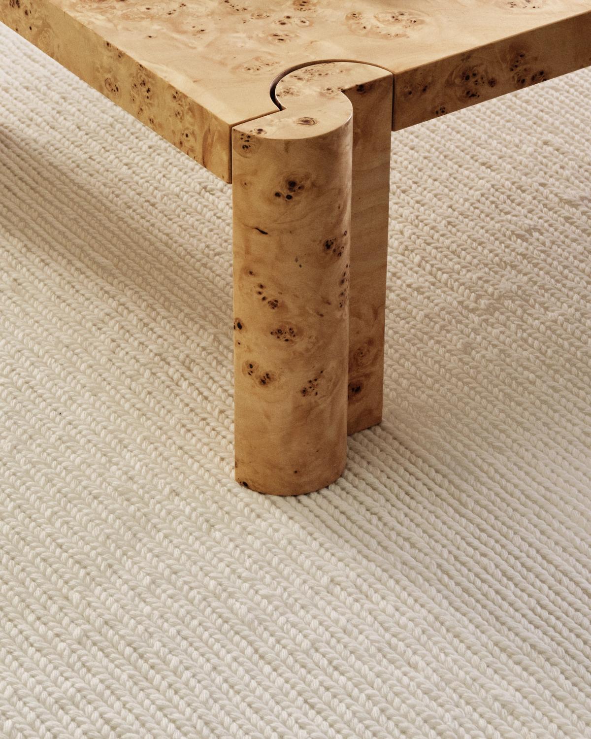 Gros plan du tapis en laine tissé à plat Braid en coloris Cream sous une table basse en bois.