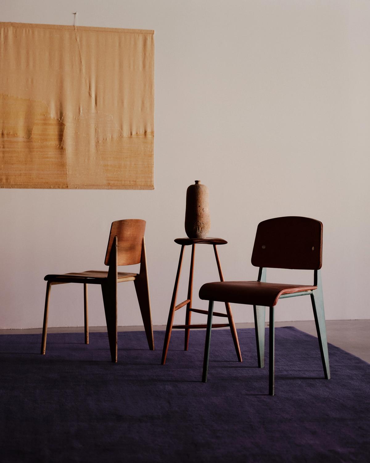 Den mjuka ullmattan Grand i färgen Lilac fotograferad med moderna stolar och en gul väggbonad.