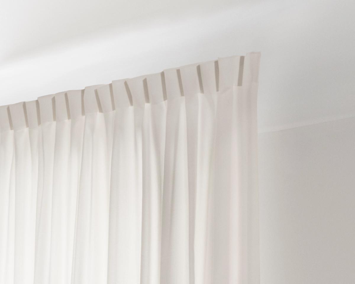 An image showing the installed The Grand wool curtains with the 1-finger hooks on a track.