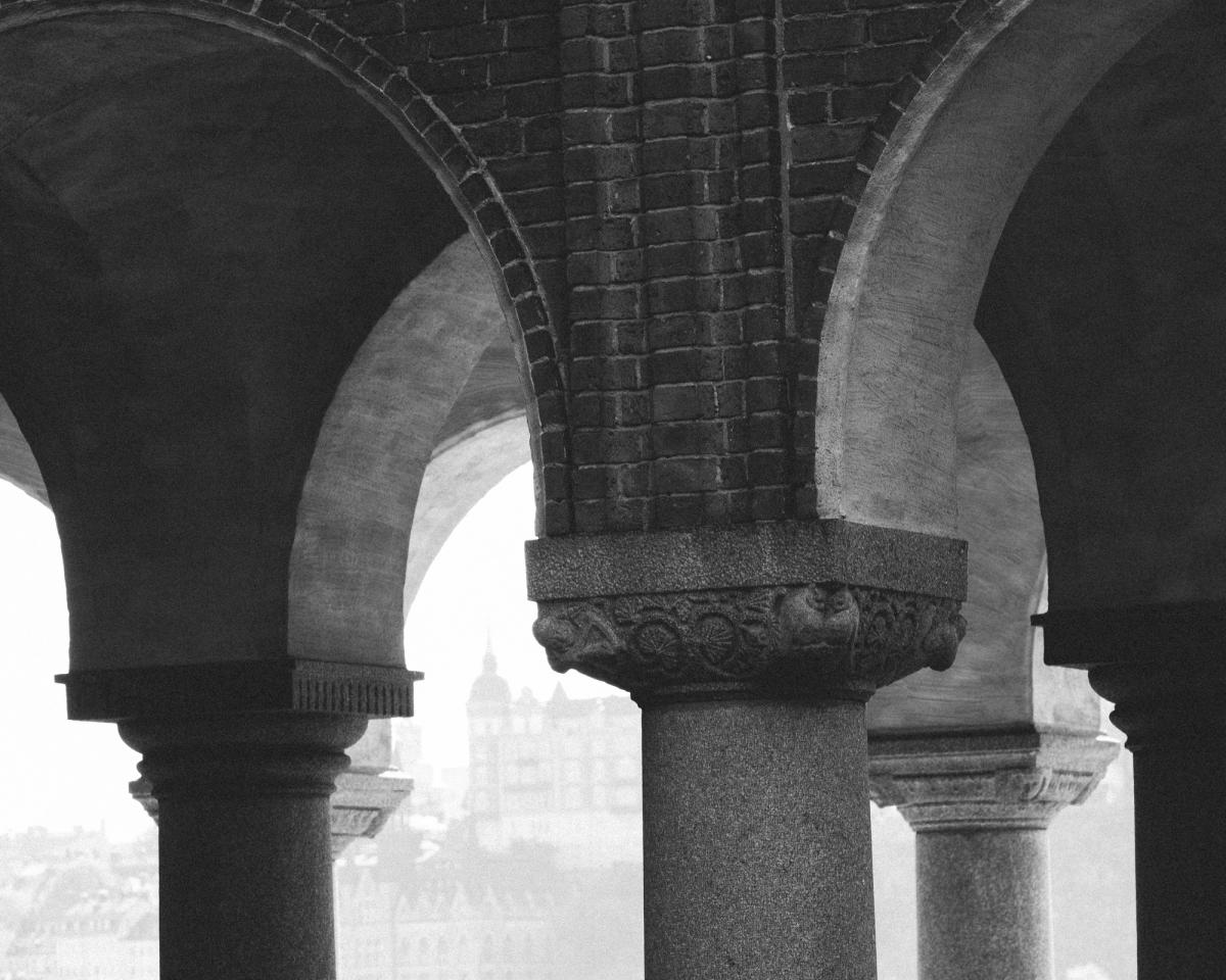 Photo du sommet de piliers en pierre reliés à un toit.