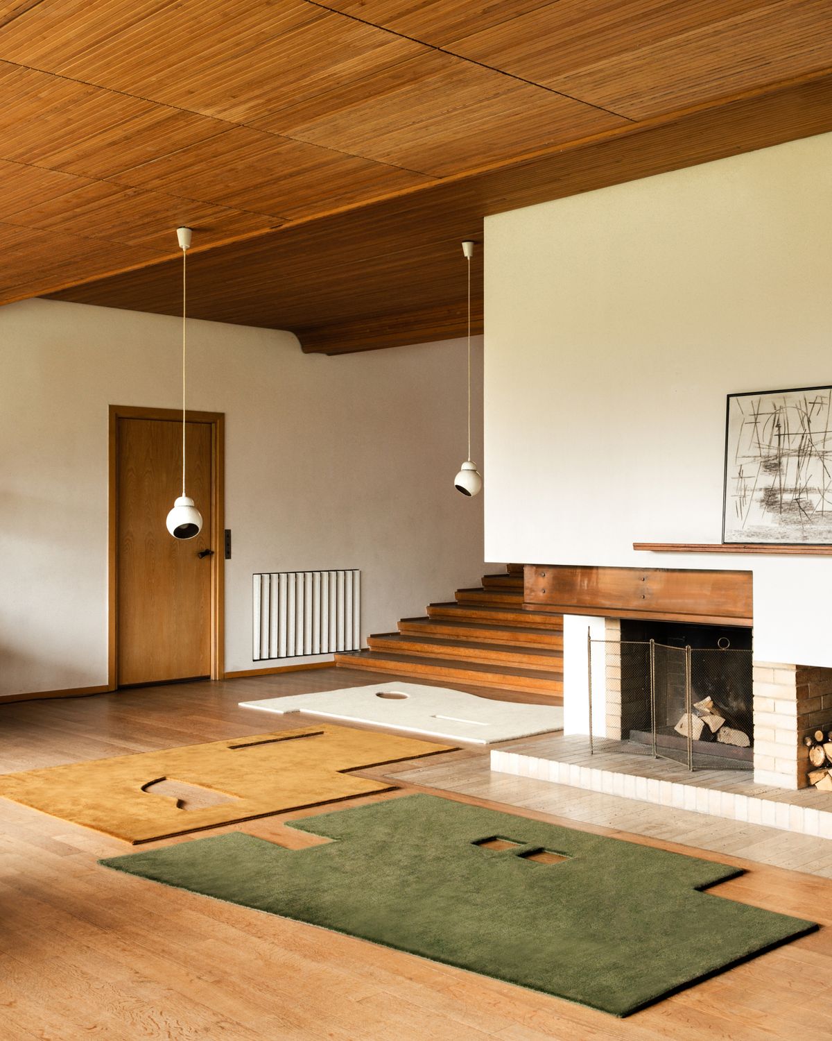 Geometrisch geformte Garance-Teppiche in den Farben Dusty White, Moss und Leo ausgestellt in einem Haus im Mid-Century-Stil.