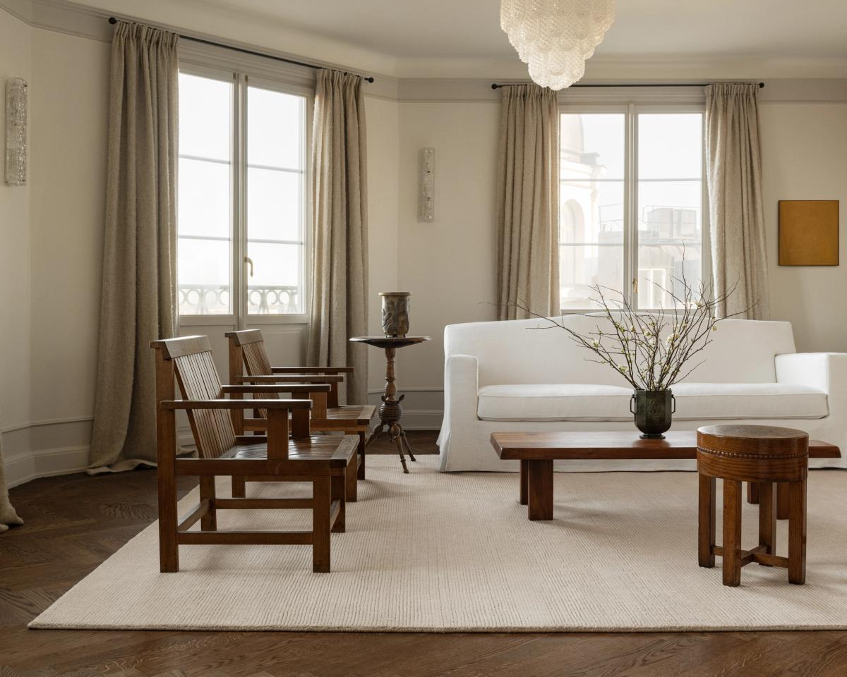 Teppich Park in der Farbnuance Almond, gespiegelt in einem hellen Wohnzimmer mit Holzmöbeln und einem weißen Sofa in Stockholm, Schweden.