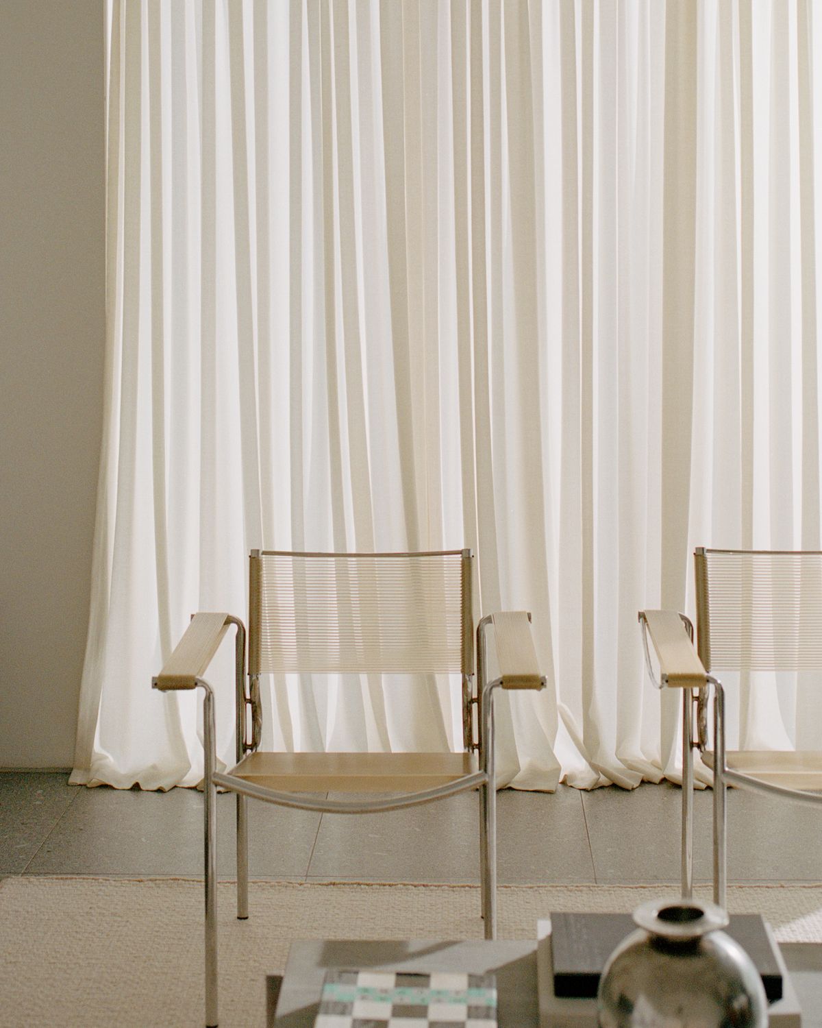 Wool flatweave rug Zero Basket Sand Mix photographed in a modern living room with light colored furniture and concrete interior details in Falsterbo, Sweden.