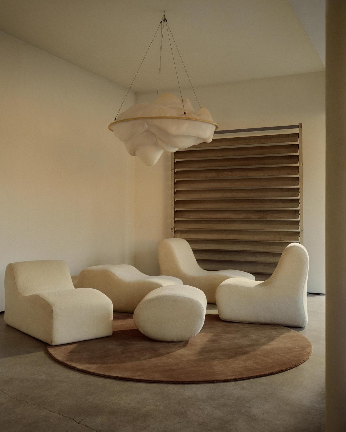 Mattan Grand Round i färgen Chestnut, placerad under flera skulpturala krämfärgade fåtöljer.