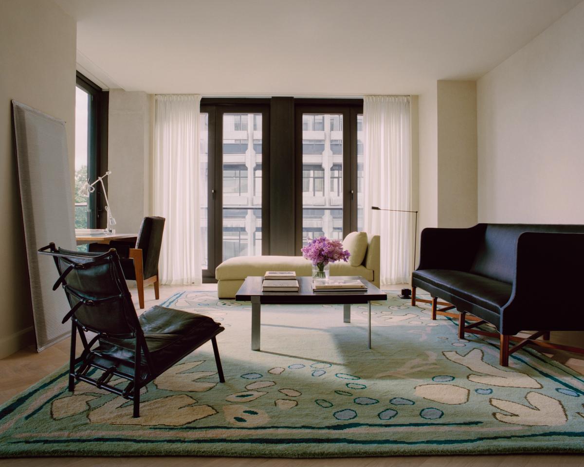 Giverny en Green photographié dans un salon lumineux aux grandes fenêtres. Mis en scène avec des sièges modernes aux accents foncés.