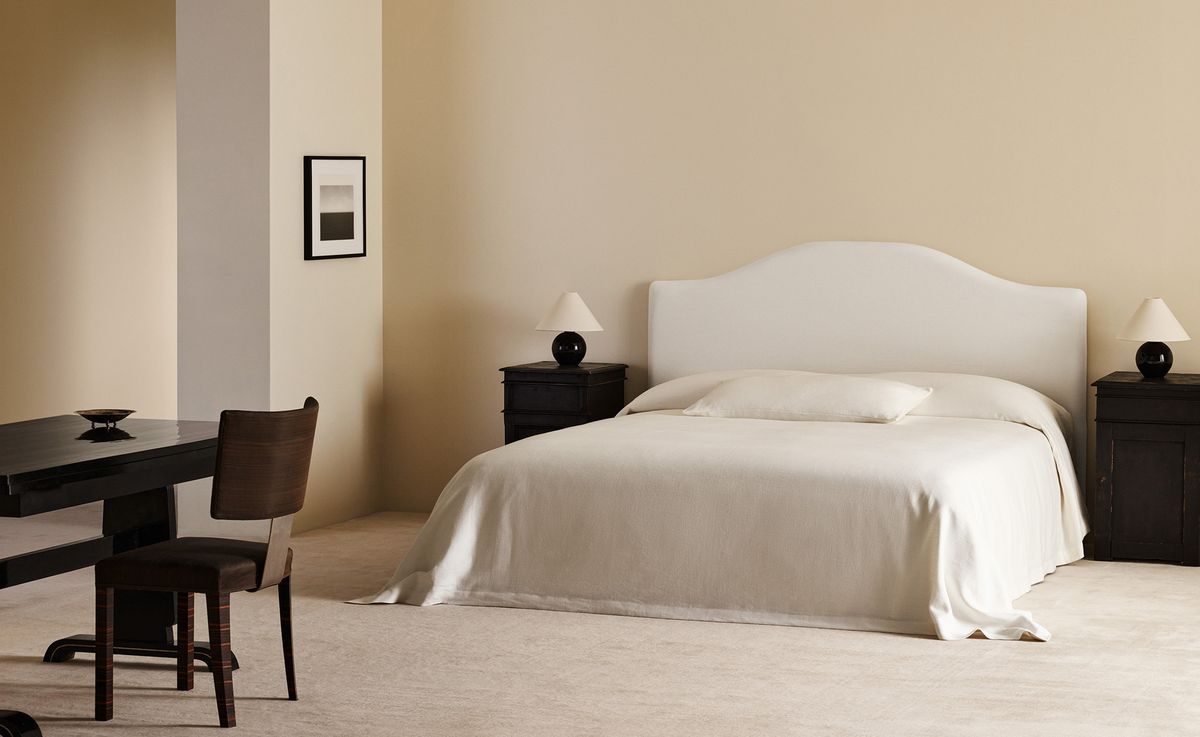 A serene bedroom featuring the Crown Headboard in Warm White, paired with the Studio Linen bedspread in White for a soft, harmonious atmosphere.