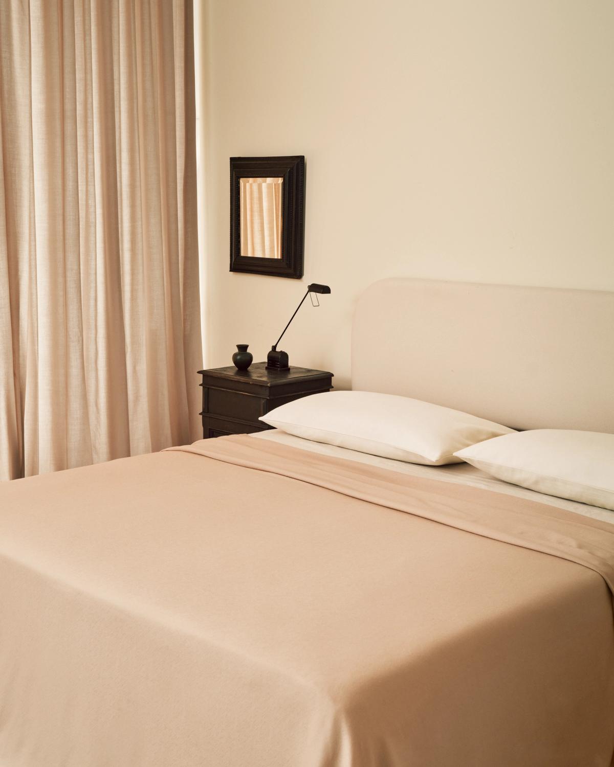 Les rideaux Grand Old Rose photographiés dans une chambre avec des draps assortis à Stockholm, Suède.