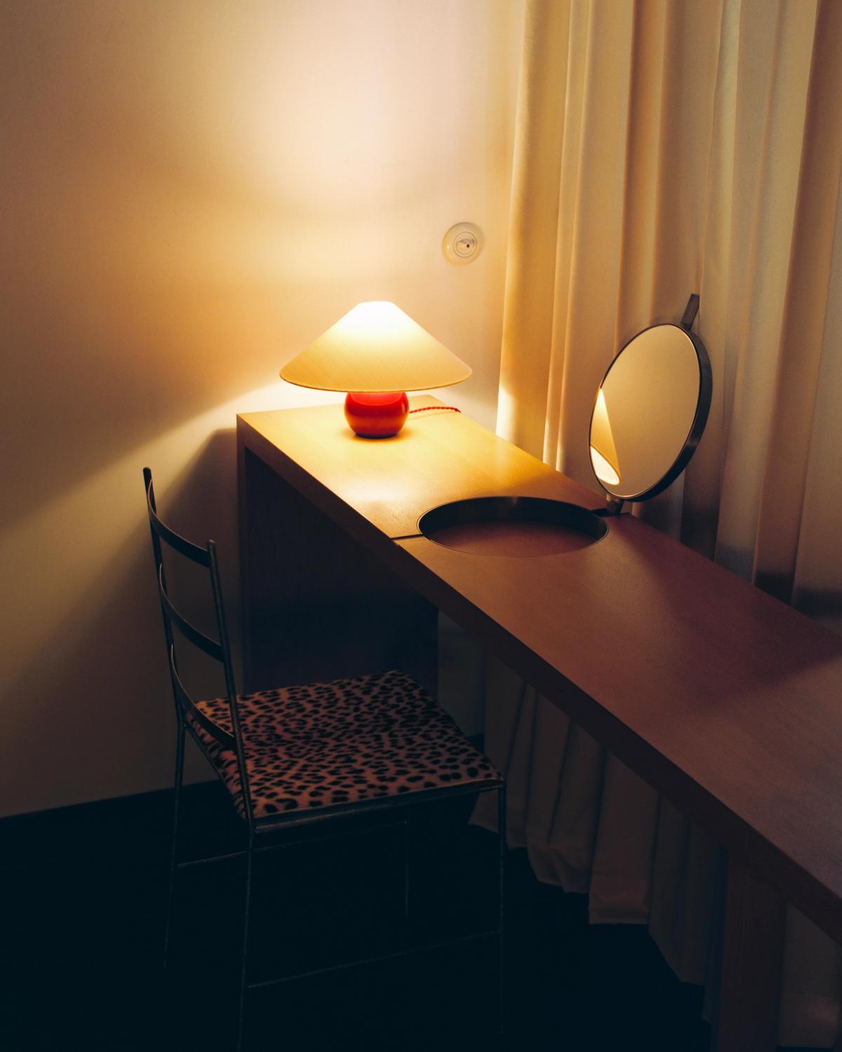 The Sheer in Sunrise, photographed in soft morning light beside a wooden vanity, where the sheer warm-white curtains create an airy, sunlit feel.