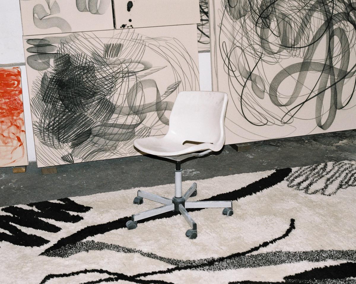 Tapis 1212/21 Aythamy Armas sous une chaise avec des œuvres d’art aux motifs similaires en arrière-plan.