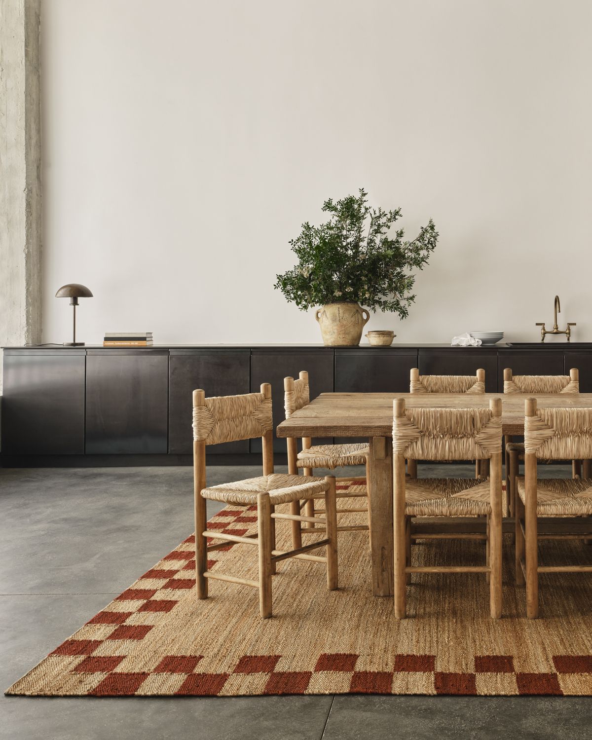 Jute rug Border Red pictured in a stunningly open spaced dining room with a wooden long table and matching chairs in Athens, Greece.