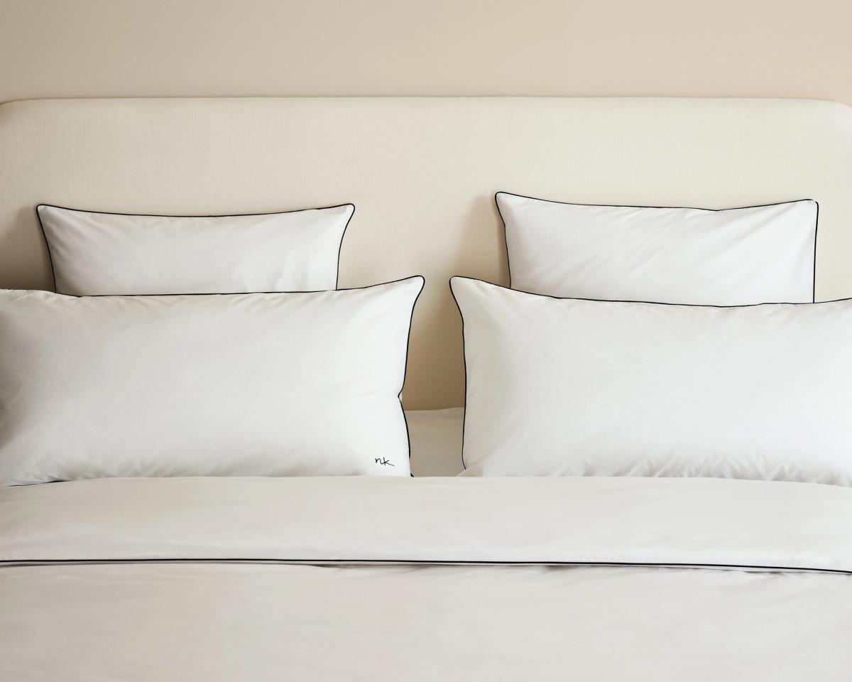 Lit décoré avec la tête de lit Signature en Warm White, habillé de la collection Percale Bedding en Crisp White/Black.