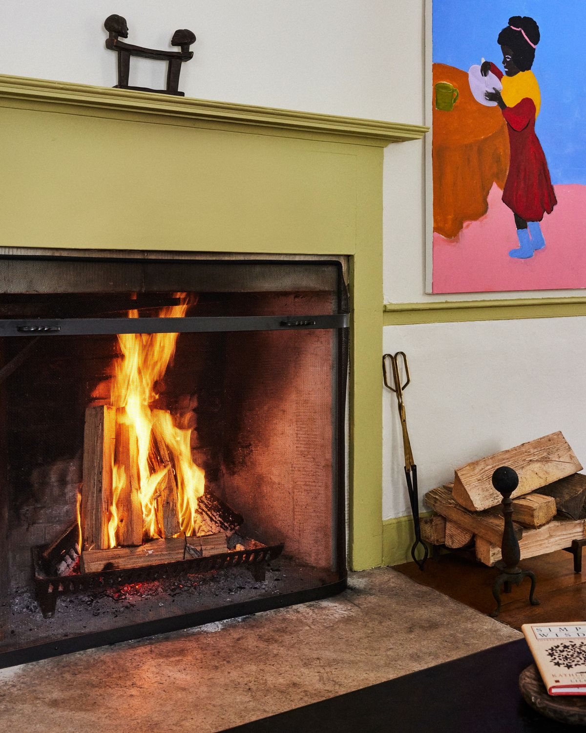 Open fire place in the color green and colorful decorations.