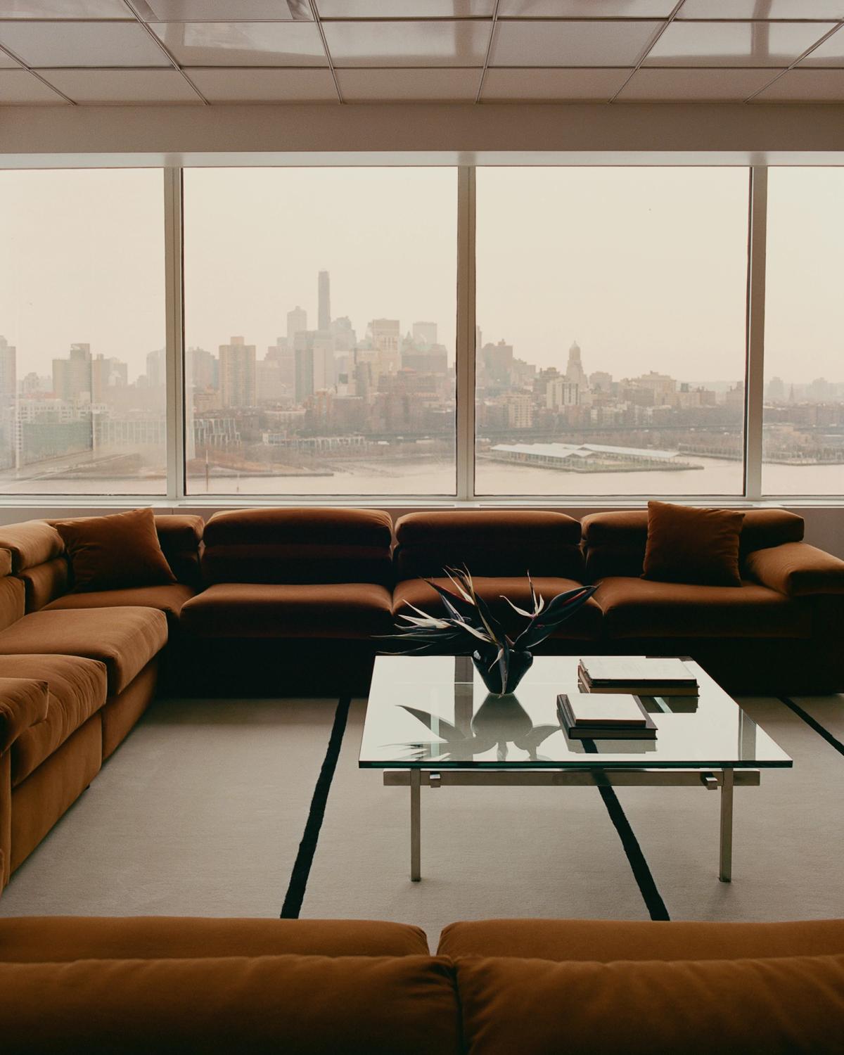 Mattan Norr Mälarstrand 01 i färgen Dusty White/Black visad i ett stilrent modernt vardagsrum i en skyskrapa i New York, ihop med en brun sammetsoffa och soffbord i glas.