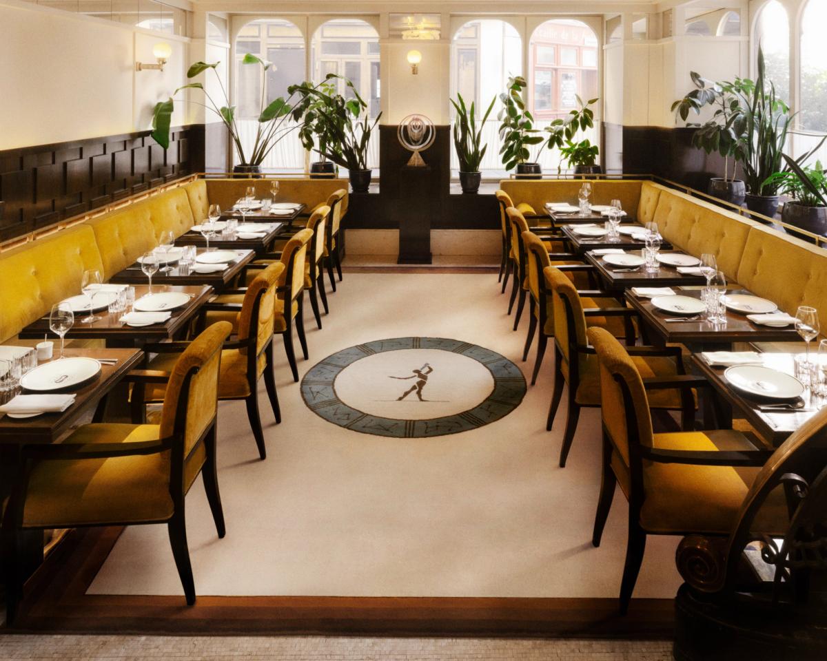 Plush wool rug Fabrizio Casiraghi - Astronomer pictured in a brightly lit restaurant with yellow velvet interior details and large windows in Paris, France.
