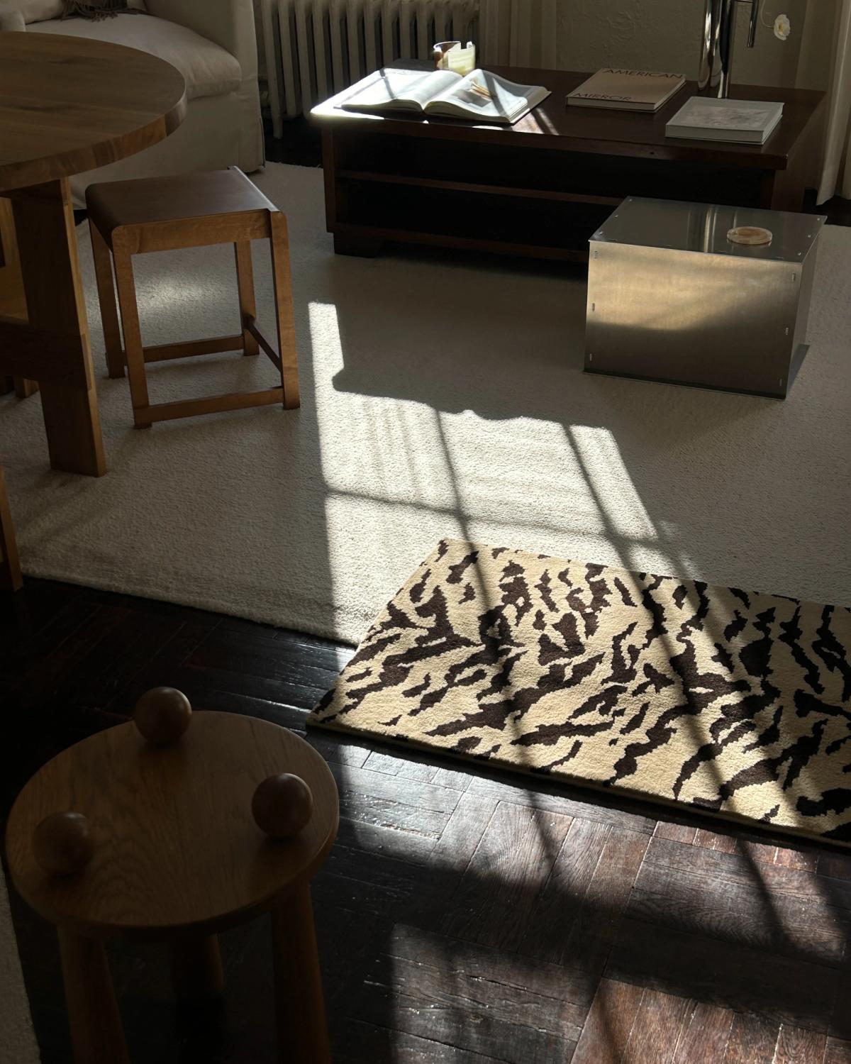 Photograph of Jessie Andrew's living room with neutral coloured furniture and a large sample of the plush wool rug Tigris x Nordic Knots.