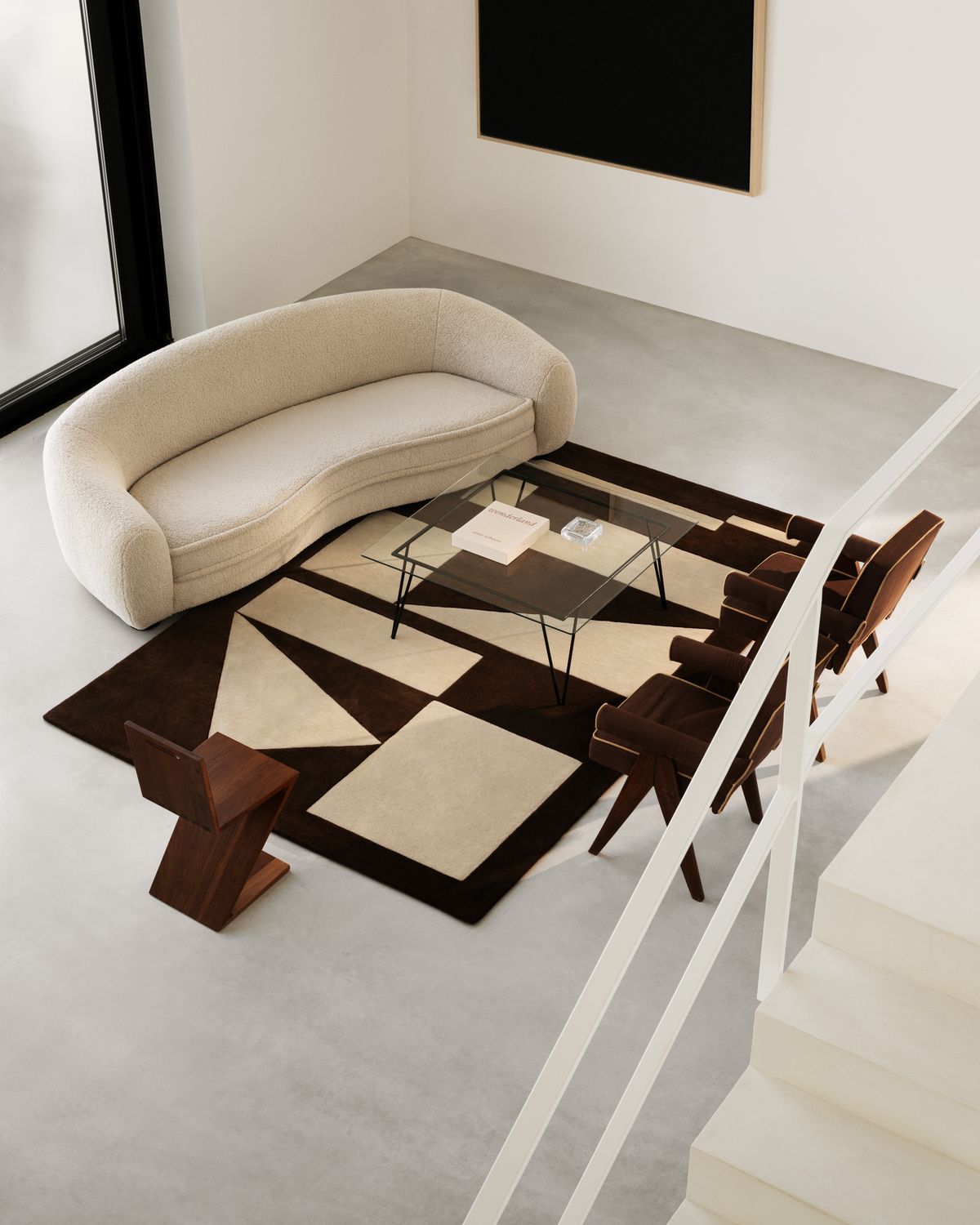 Ullmattan Untitled 03 fotograferad från en trappa, under ett soffbord i glas och konstnärliga designmöbler i dämpade färger.