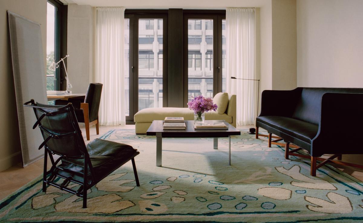 Giverny in Green photographed in a bright living room with tall windows. Styled with modern seating in dark accents.