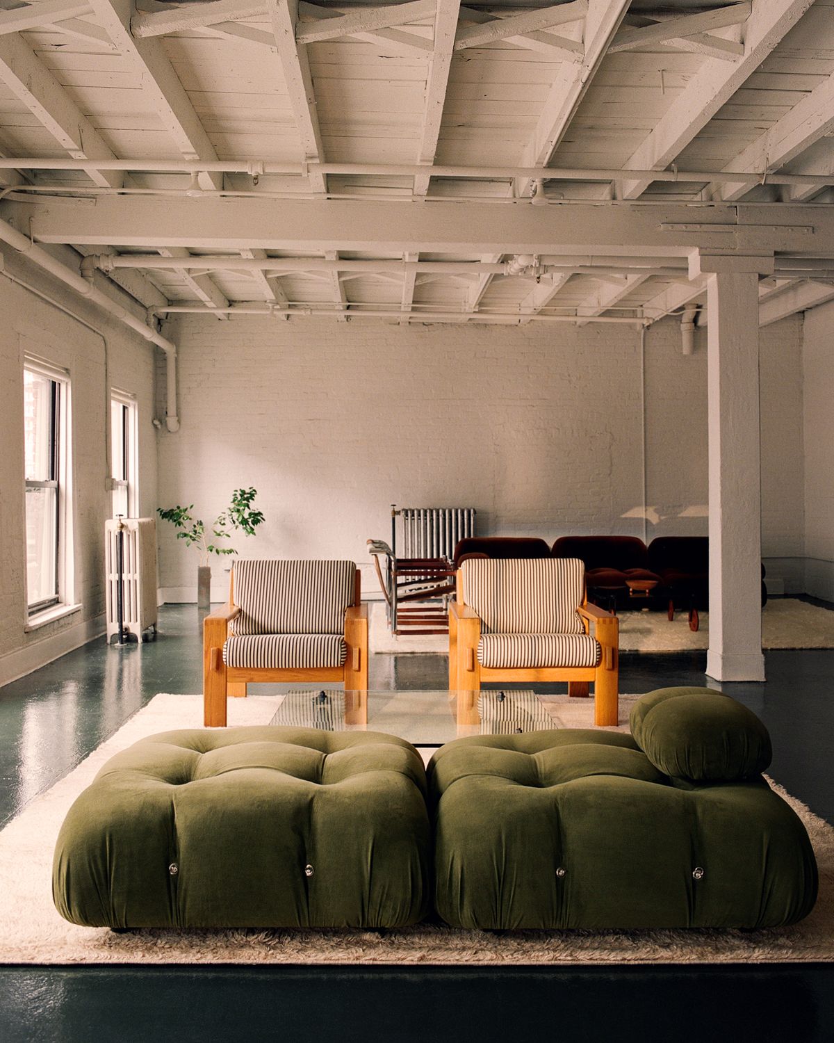 Innenaufnahme eines rauen Brooklyn-Lofts, eingerichtet mit Vintage-Möbeln und zwei zotteligen Fields-Teppichen.