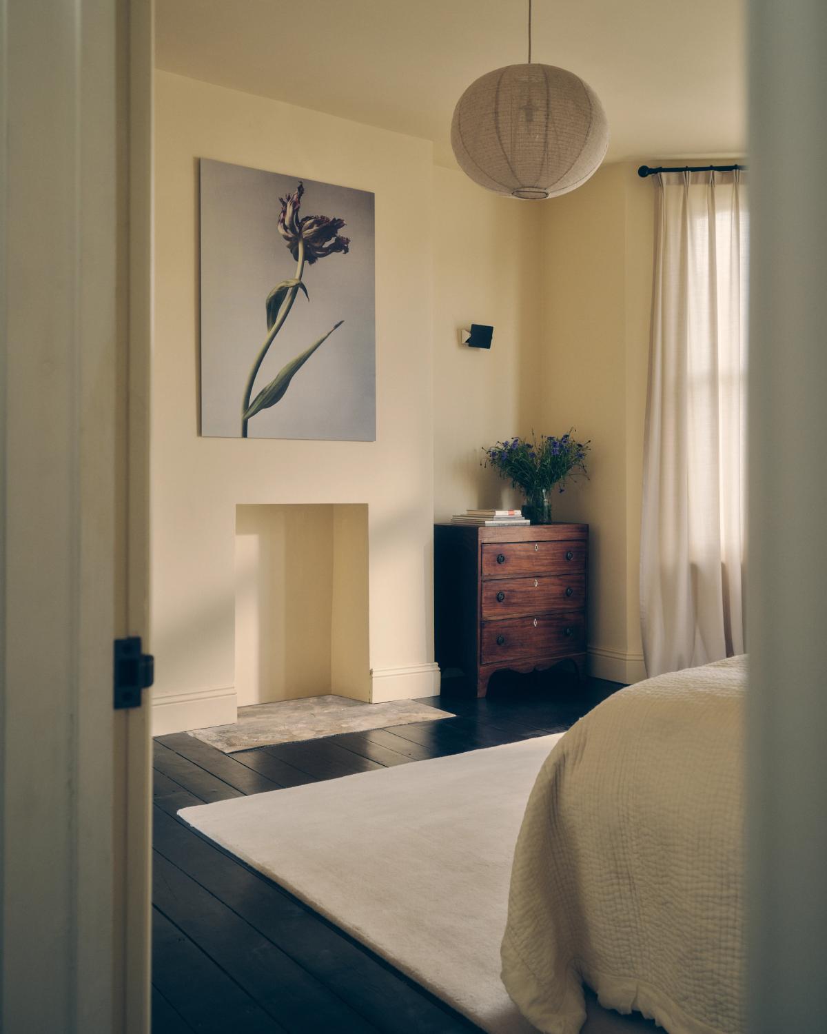 Flauschiger Wollteppich Grand in Dusty White abgebildet in einem hellen Schlafzimmer mit cremefarbenen Möbeln und Wänden.