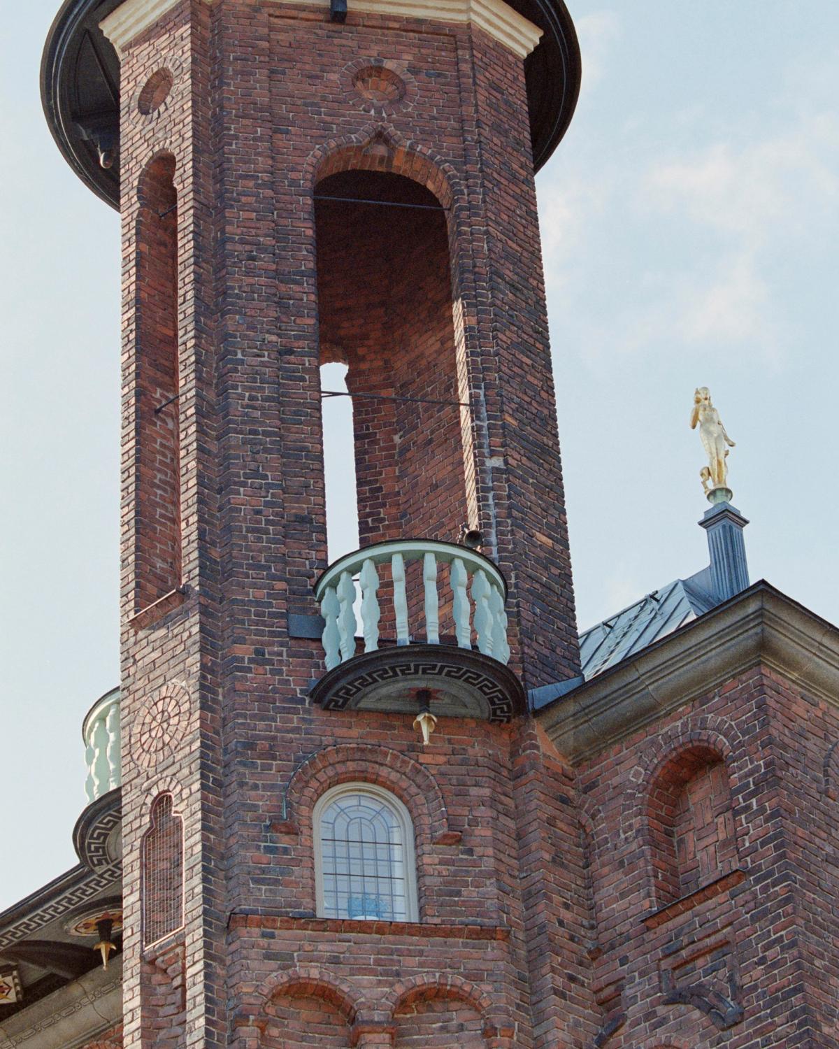 Photo du sommet d’un bâtiment majestueux en briques rouges.