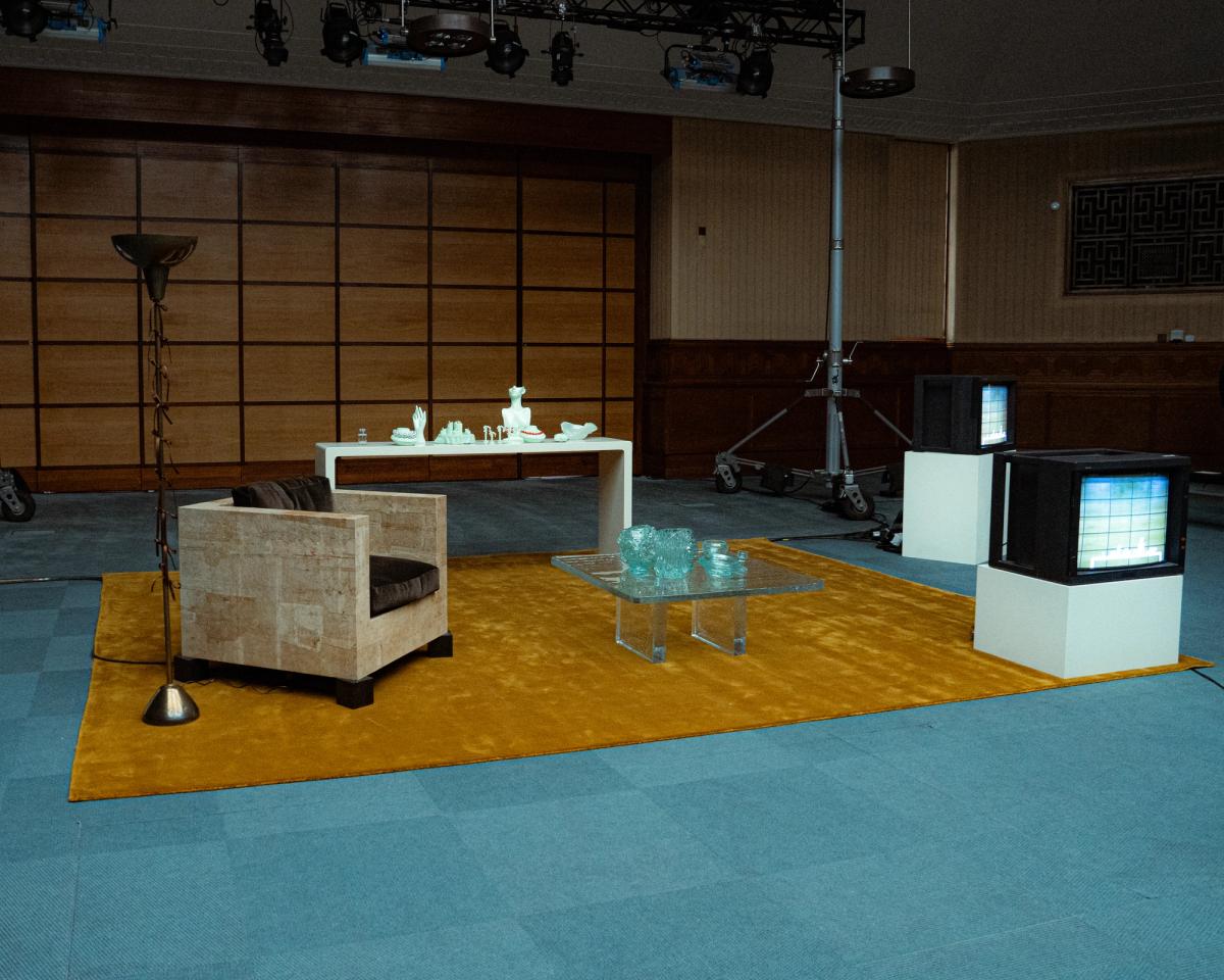 Grand Teppich in Leo ausgestellt während der London Fashion Week in einem von Innenarchitektin Hollie Bowden kuratierten Raum, mit einem sandfarbenen Sessel und einem Glastisch.