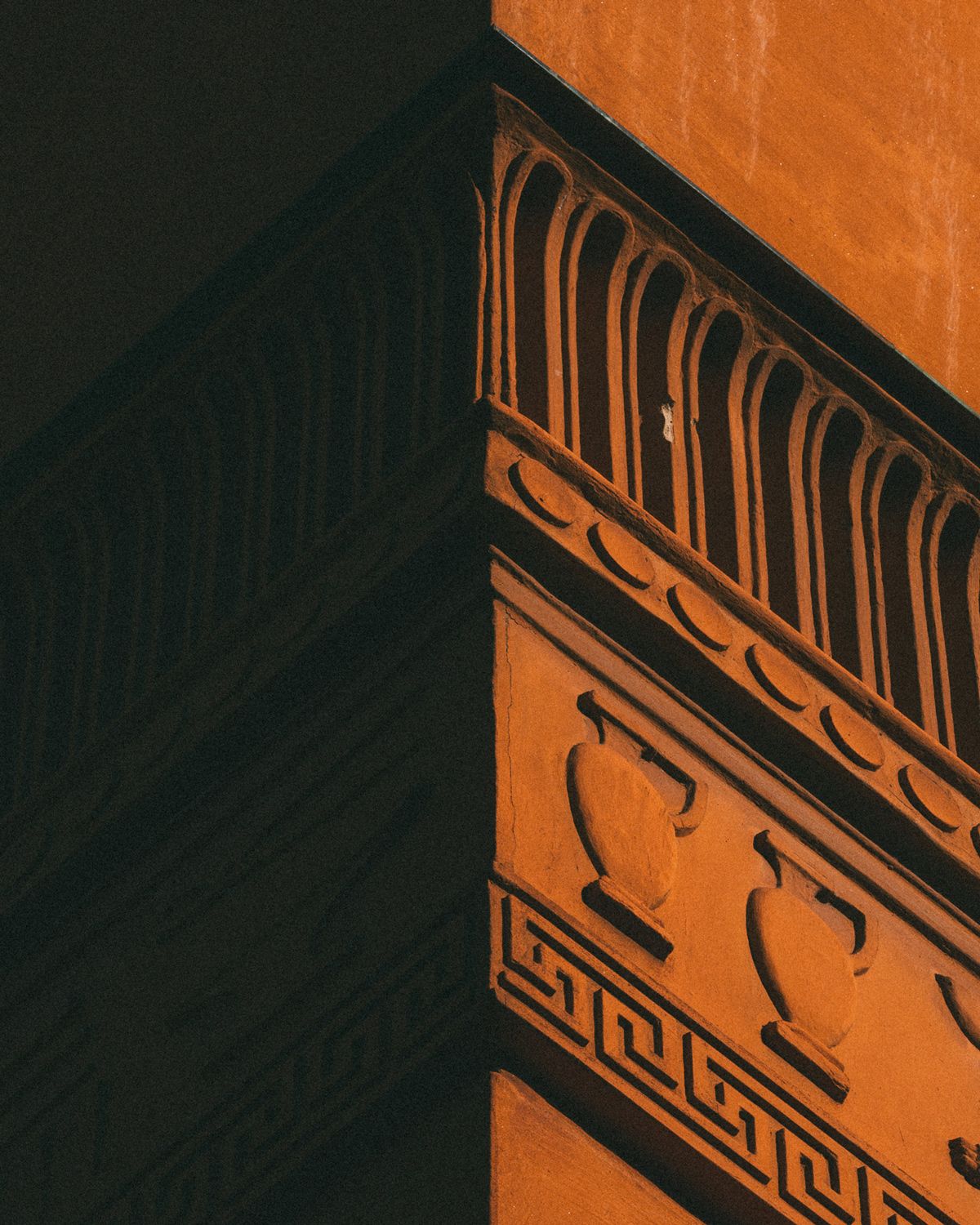 Détail architectural d’un angle en terre cuite à la Bibliothèque publique de Stockholm, avec des motifs d’urnes et des ornements géométriques.