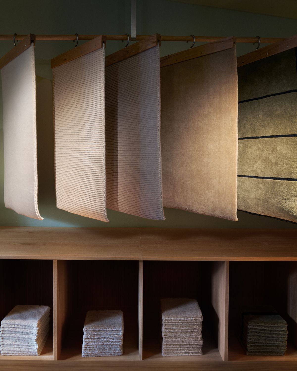 Mattprover hängande på ett ställ i Nordic Knots showroom.