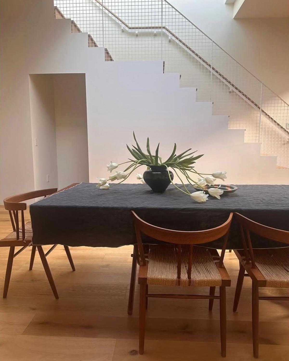 Ett vackert blomsterarrangemang som står på ett matbord i ett ljust matsalsrum.