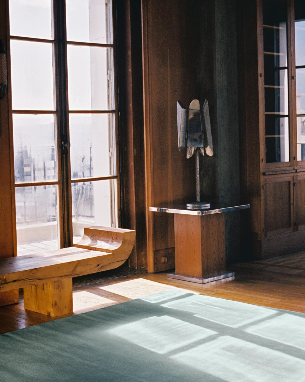 Plush wool rug Grand Pale Green pictured in a beautiful Parisian apartment with wooden interior design details and large windows.