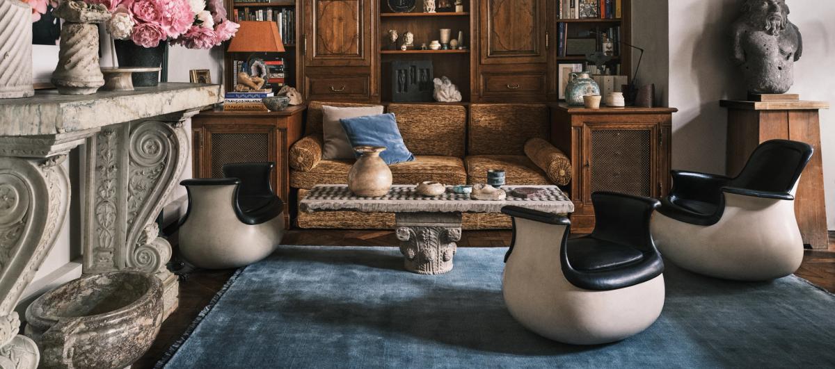 Mohair-mattan i Slate Blue visas i ett Paris-vardagsrum med skulpturala möbler, en marmorspis och träpaneler, vilket skapar en sofistikerad och konstnärlig atmosfär.