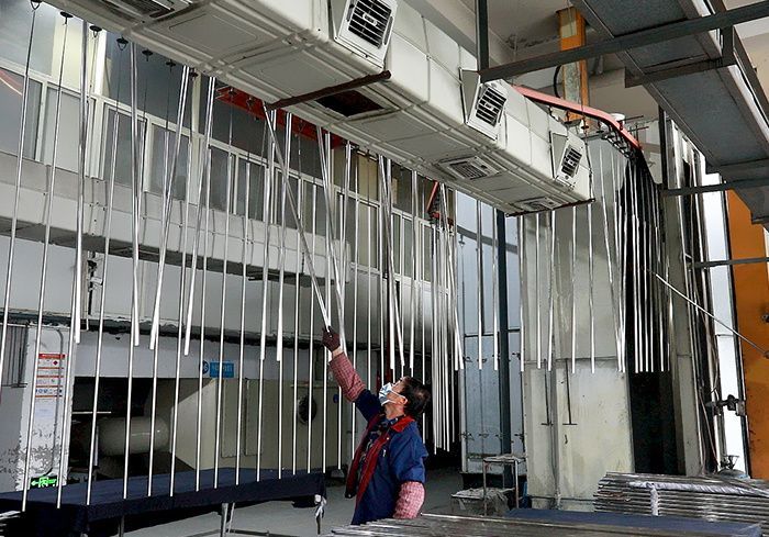 Worker inspecting hanging curtain rods