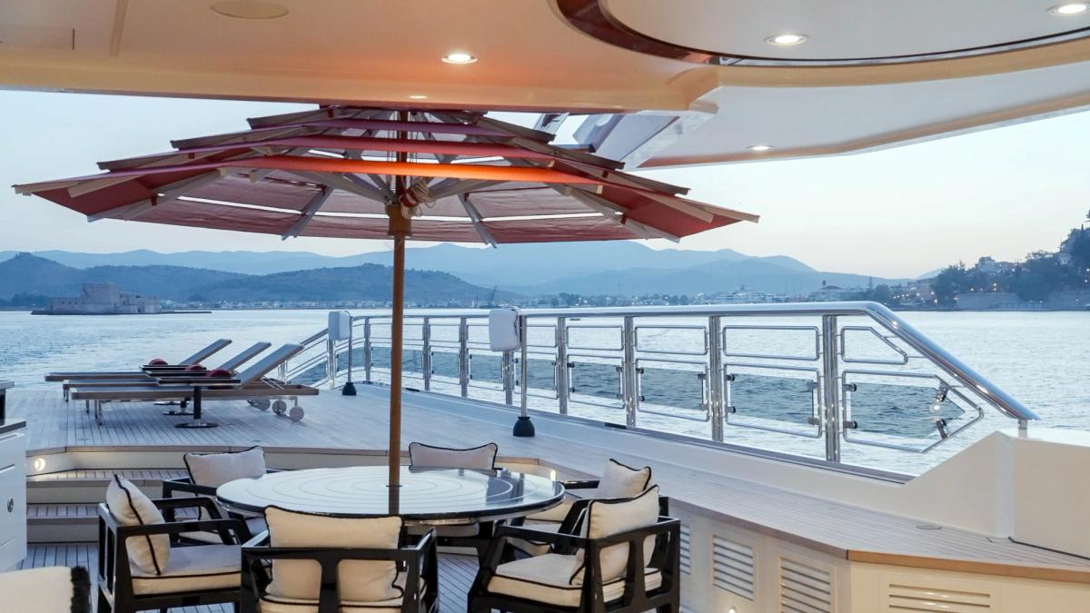 ALFA NERO shaded deck dining table under a parasol, 82m Oceanco motor yacht for sale