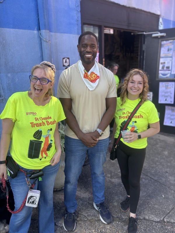 Three smiling people at the Trash Bash, two in neon event shirts