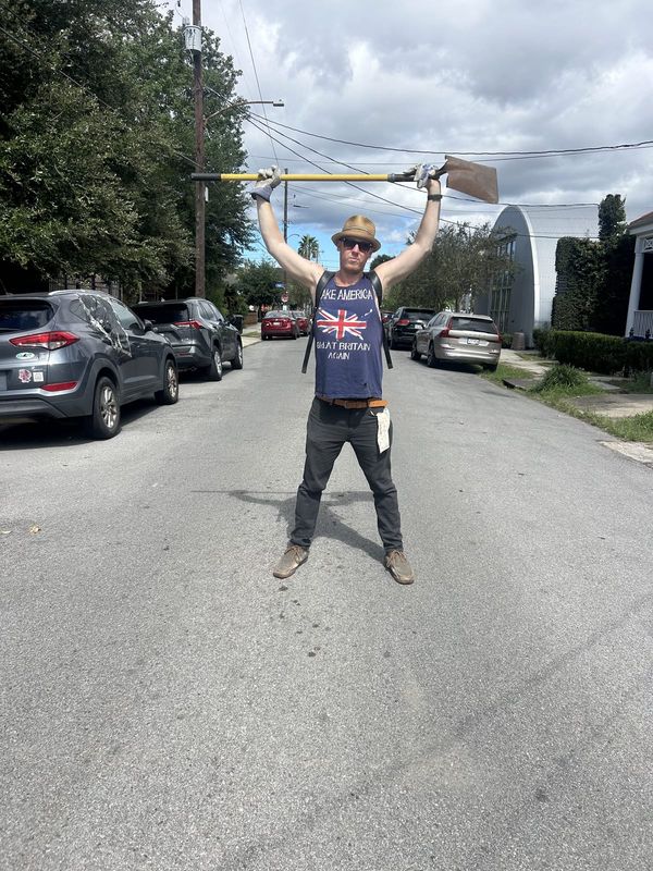 A volunteer celebrating in the middle of the street with arms raised