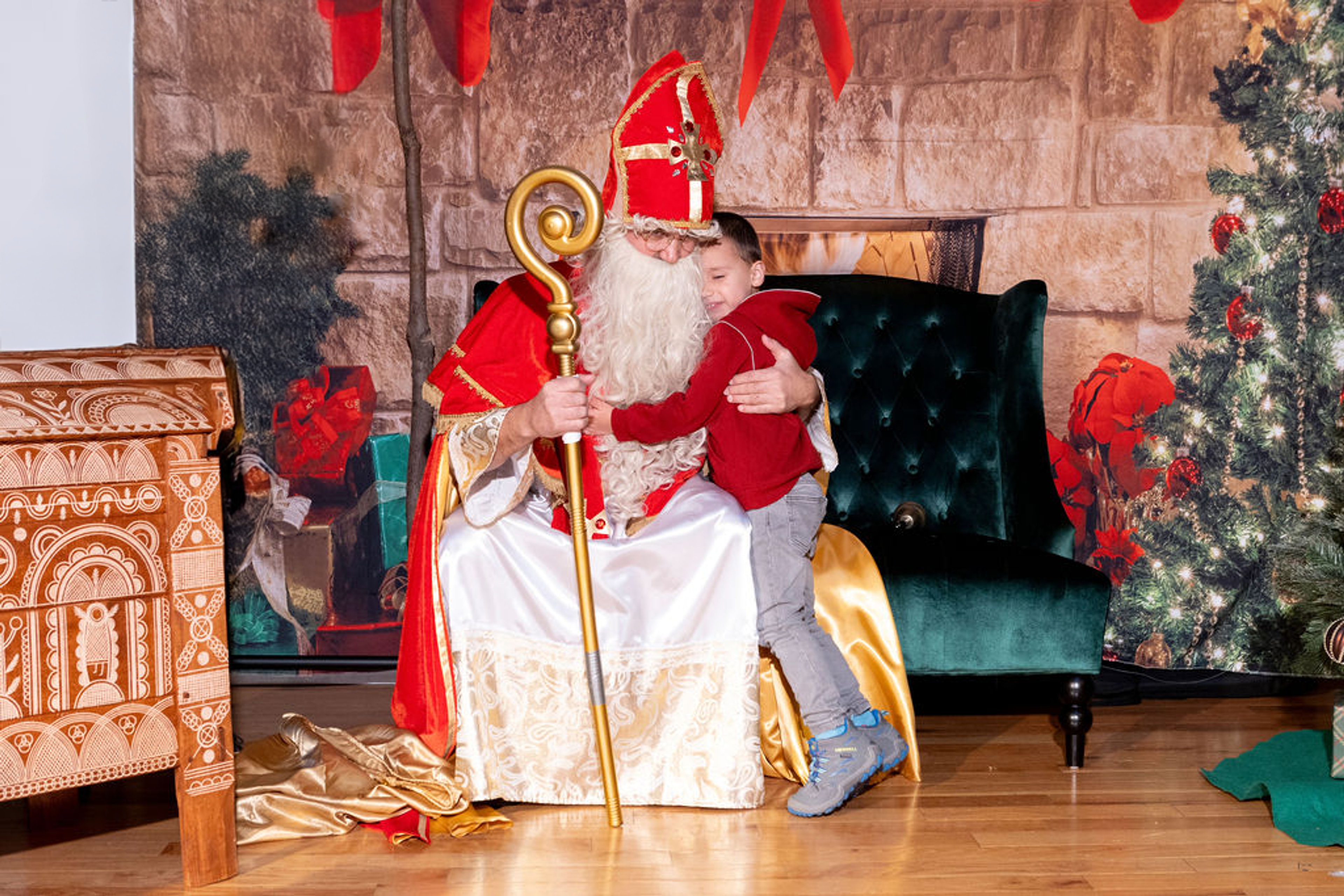 little boy hugging santa on a couch