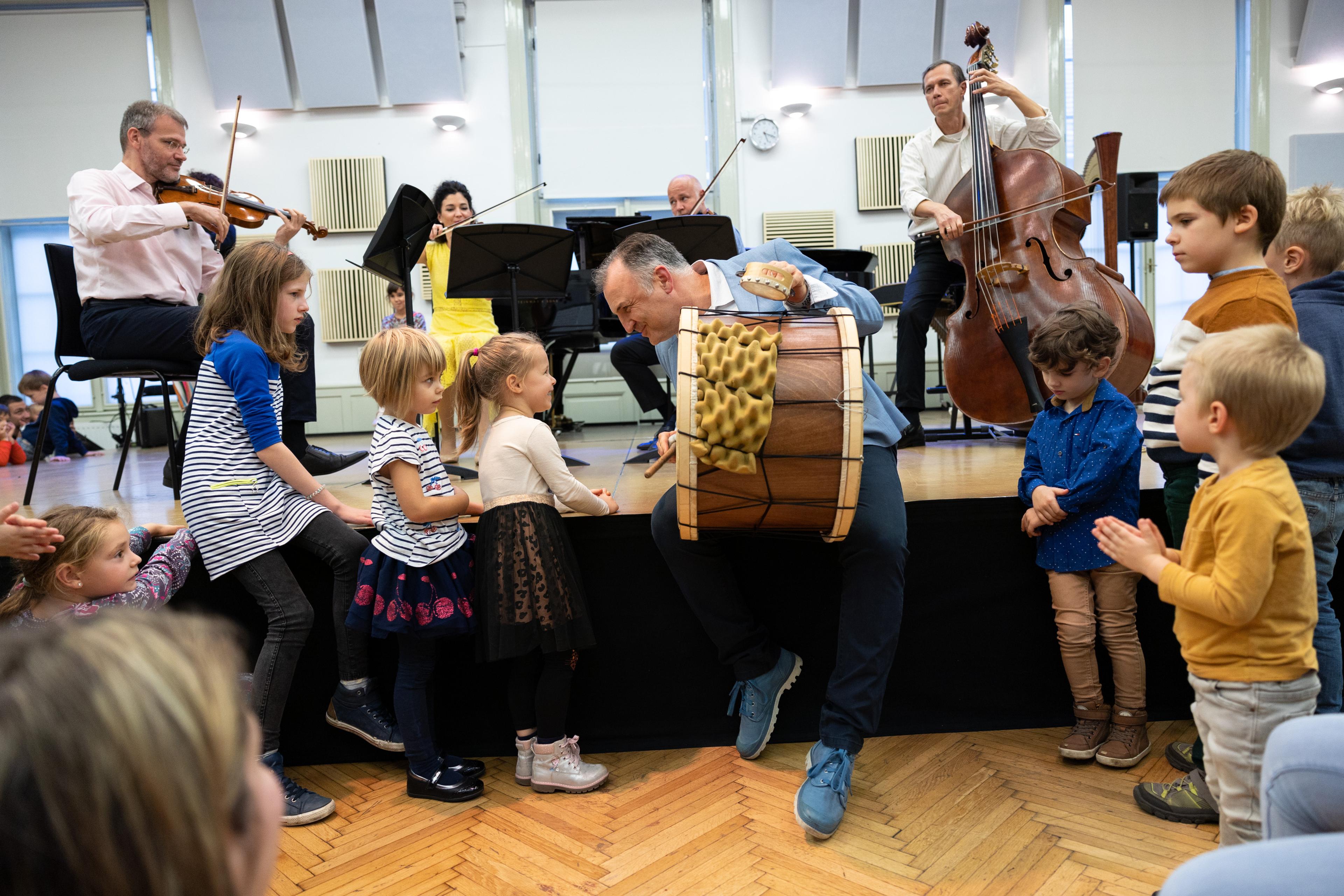 a man showing group of children musical instruments