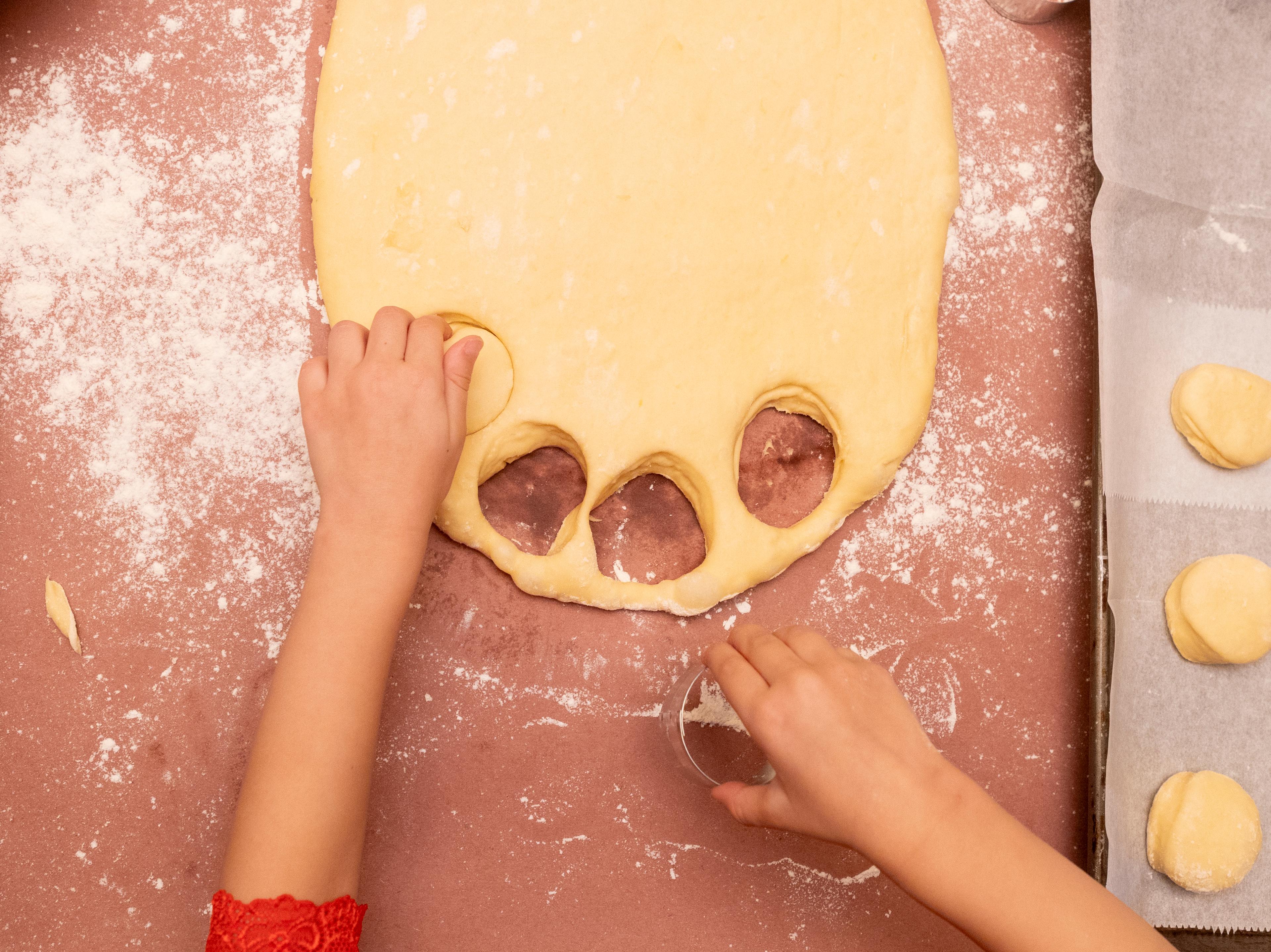 child cutting out donuts from dough