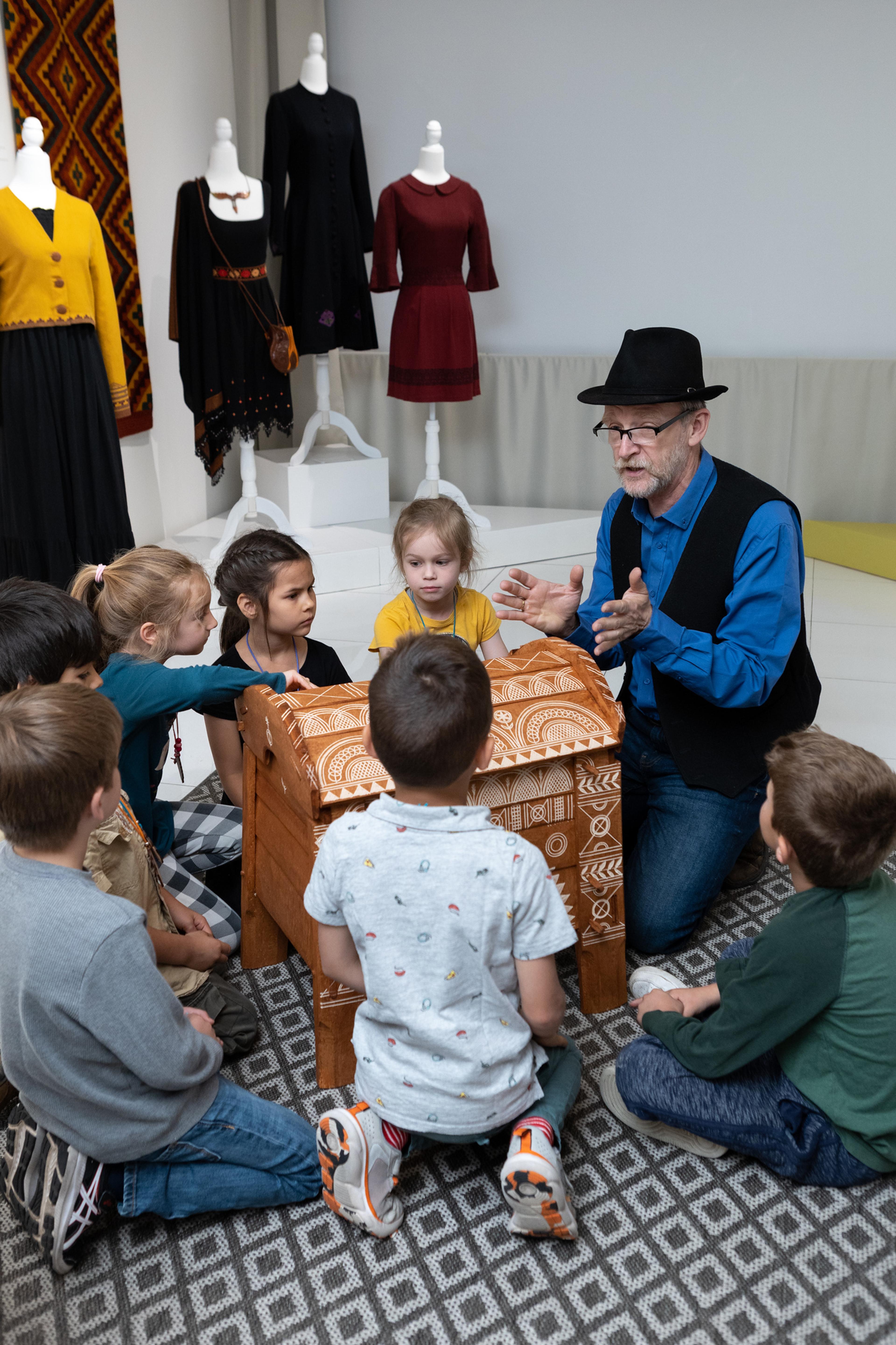 man explaining something to a group of children
