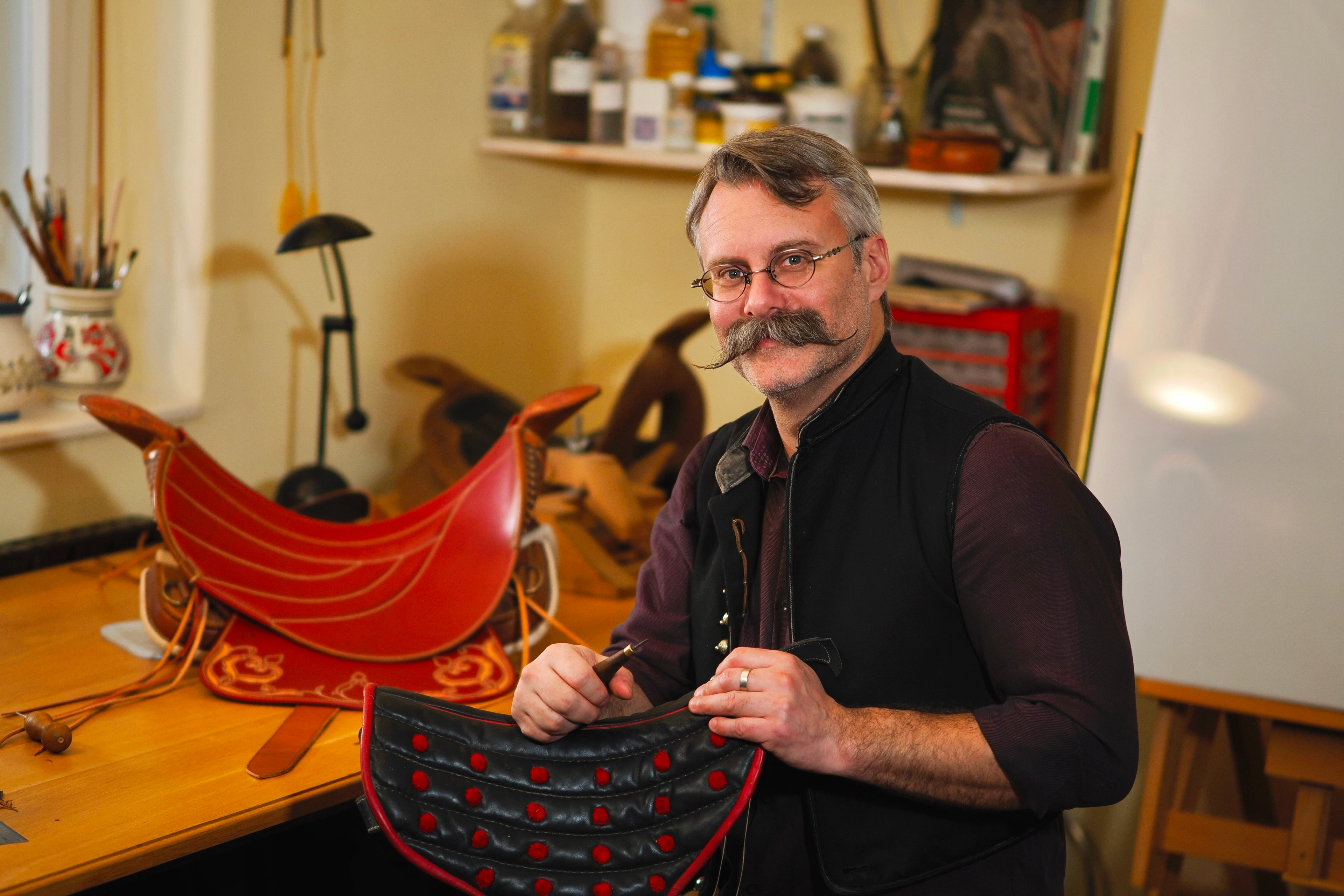 man holding a handmade leather craft