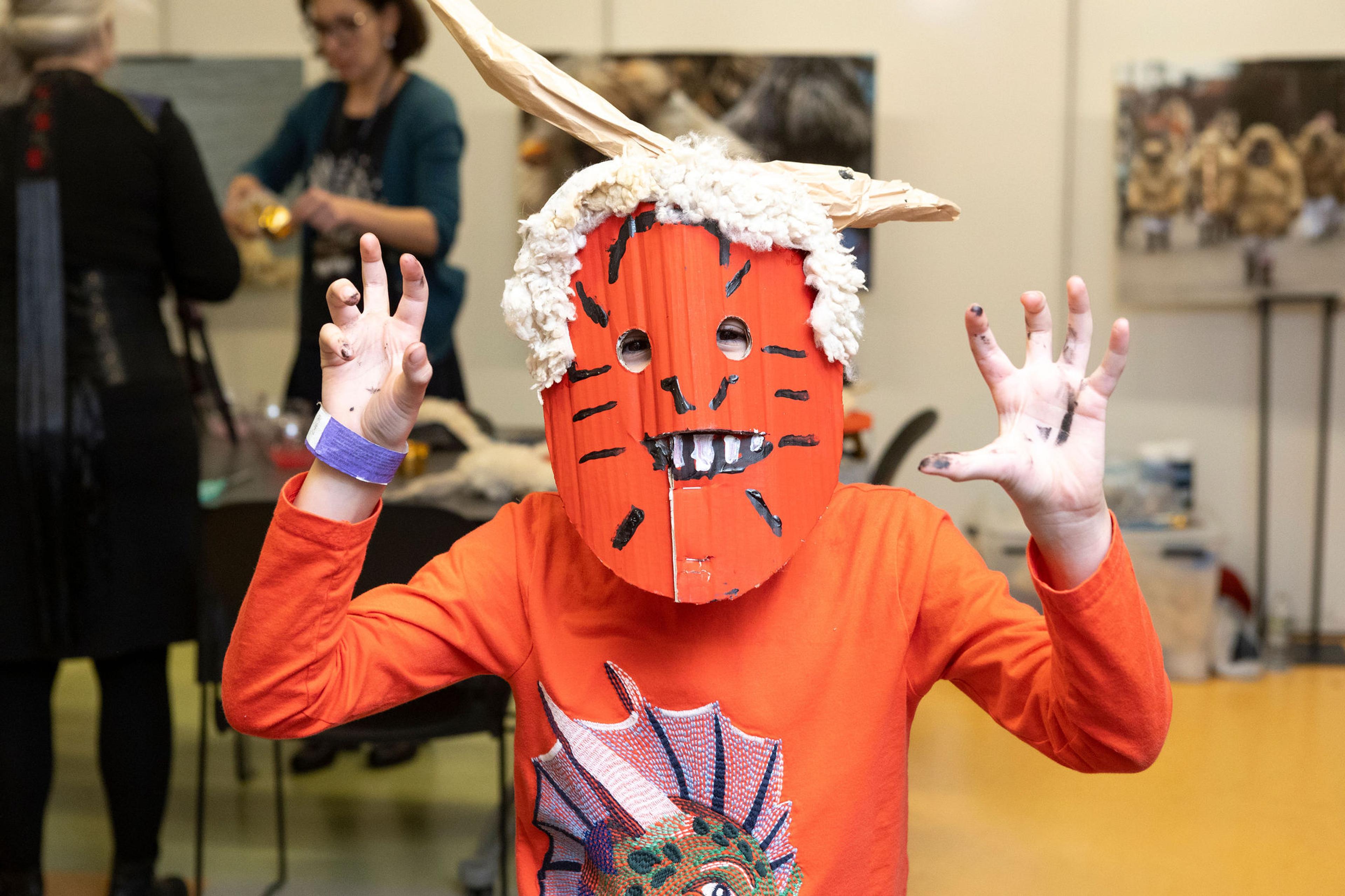 young boy wearing a painted mask