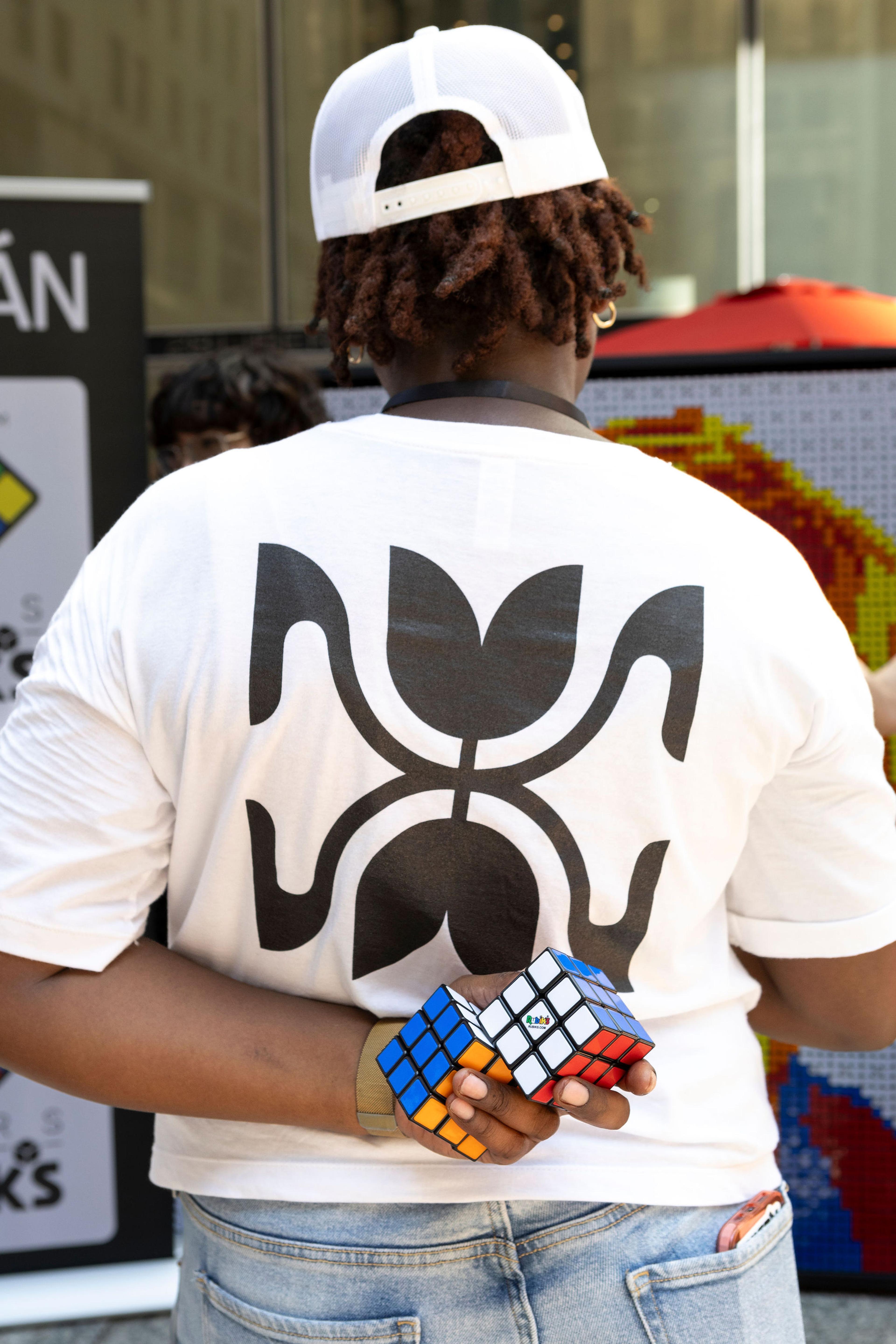 A volunteer in a Tulipan shirt holdung Rubiks cubes