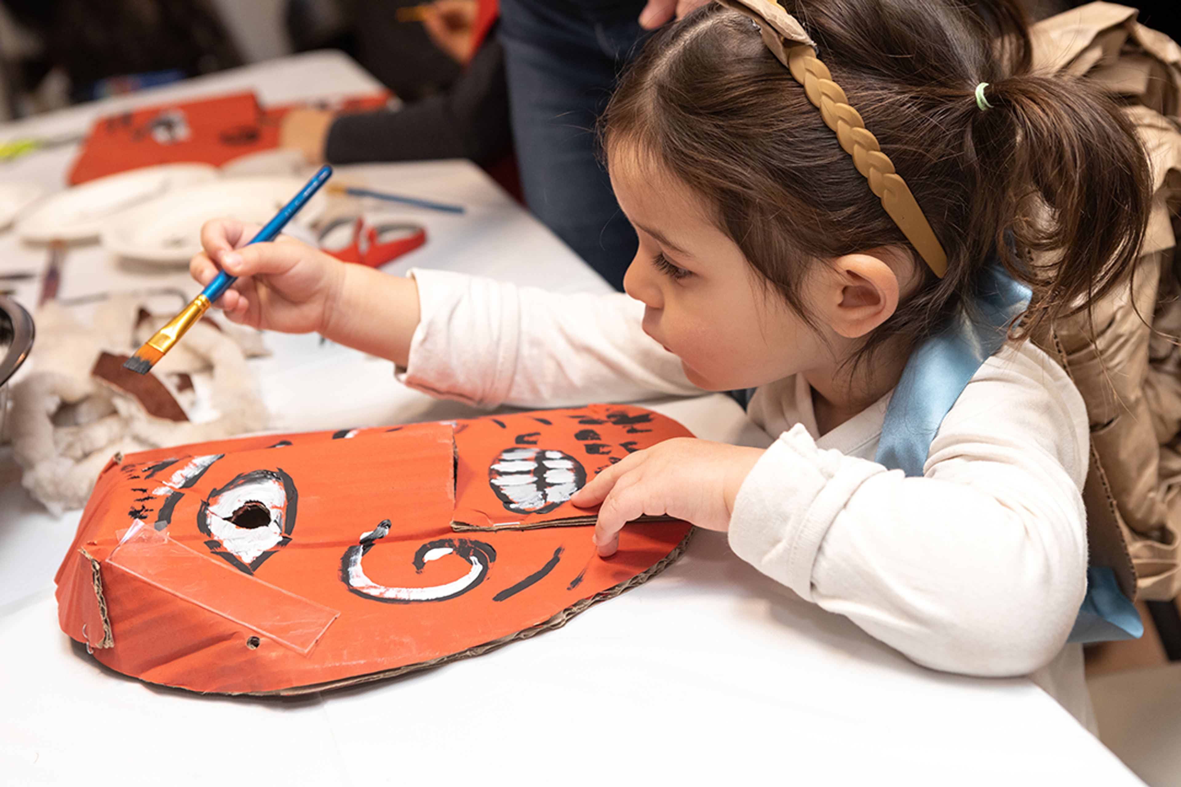 little girl painting a hungarian carnival mask