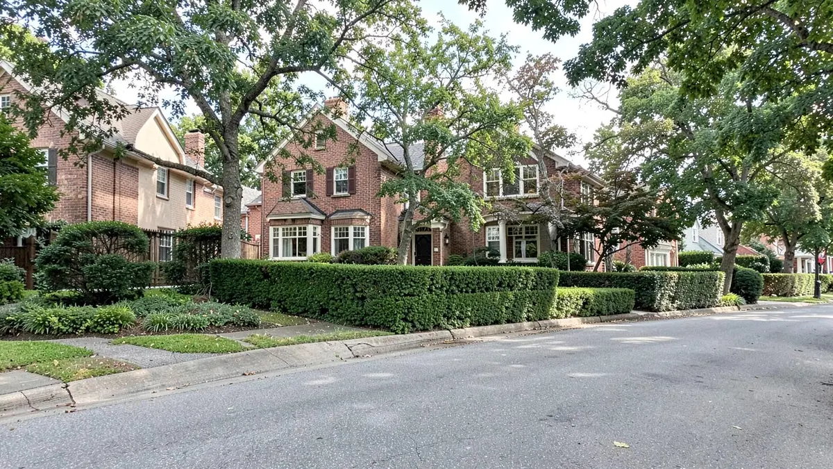 Brick and stucco homes on a curving residential street in Great Neck, NY, Nassau County