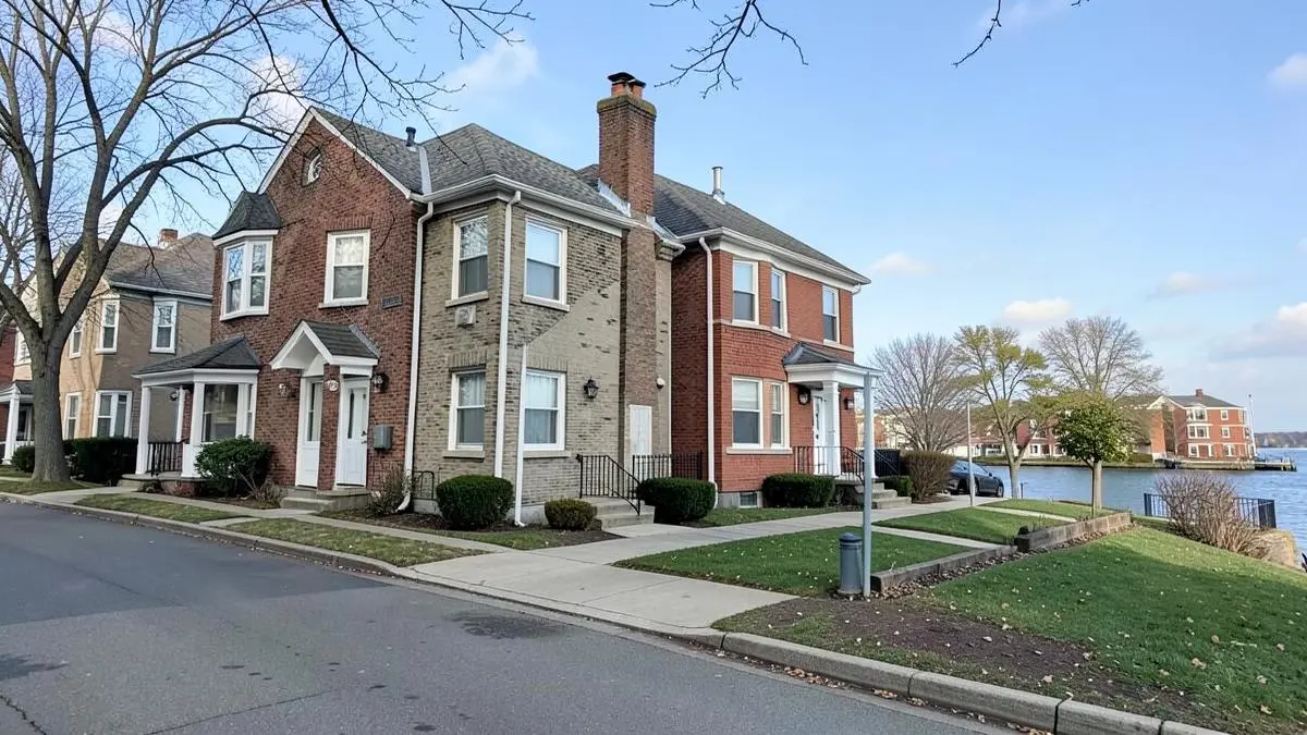 Detached brick and stucco homes on a quiet residential street near the water in Whitestone, Queens, NY