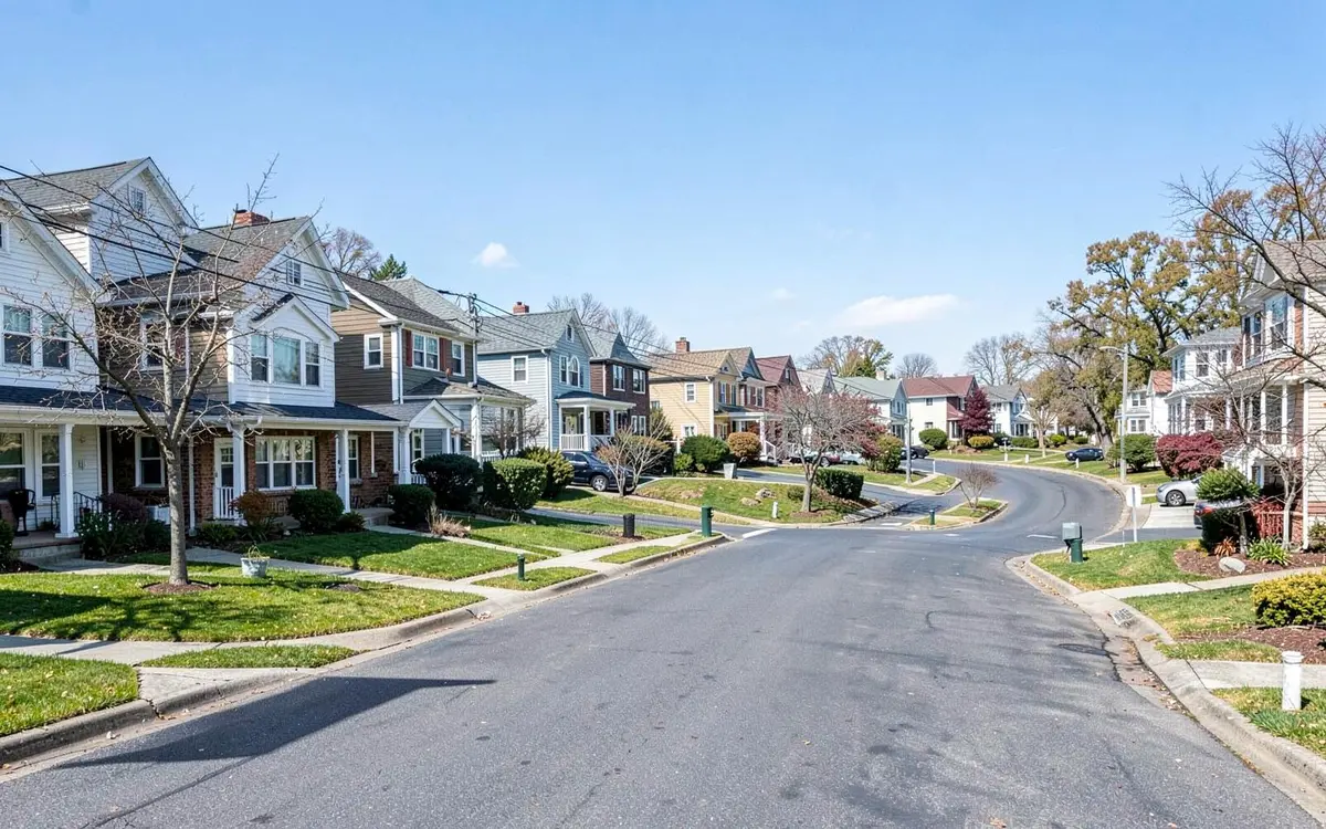 Expanded postwar cape homes on a curving residential street in Levittown, NY, Nassau County