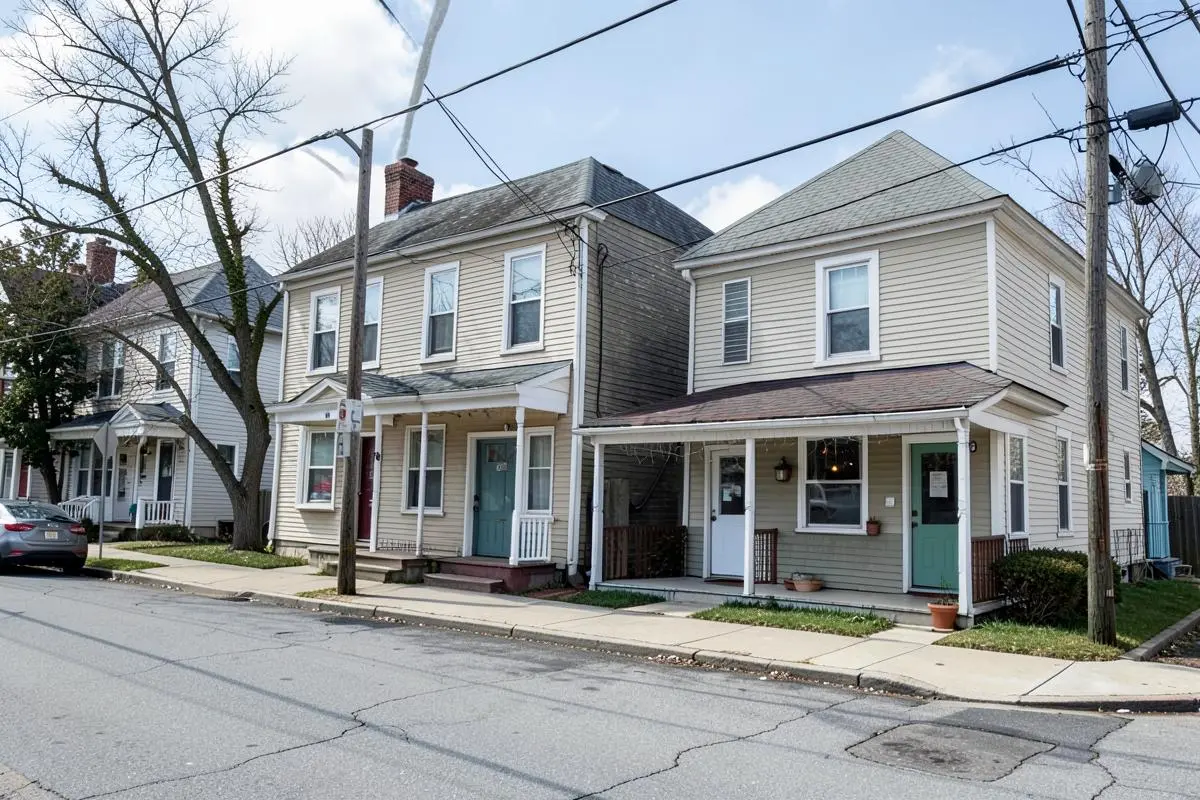 Two-family frame homes and small storefronts along a residential street in Port Richmond, Staten Island, NY