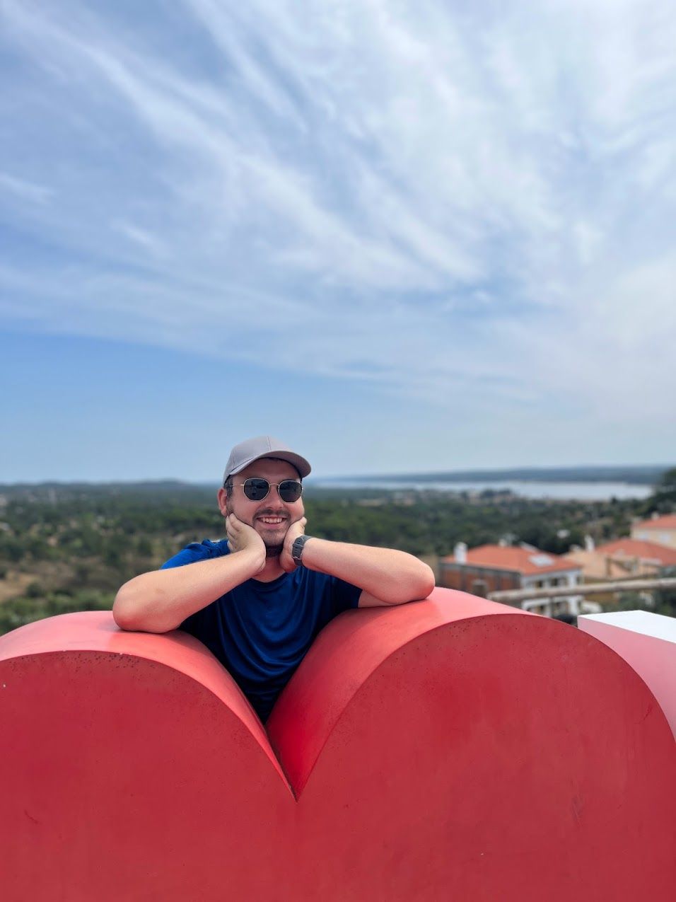 a man sitting on top of a red heart shaped object