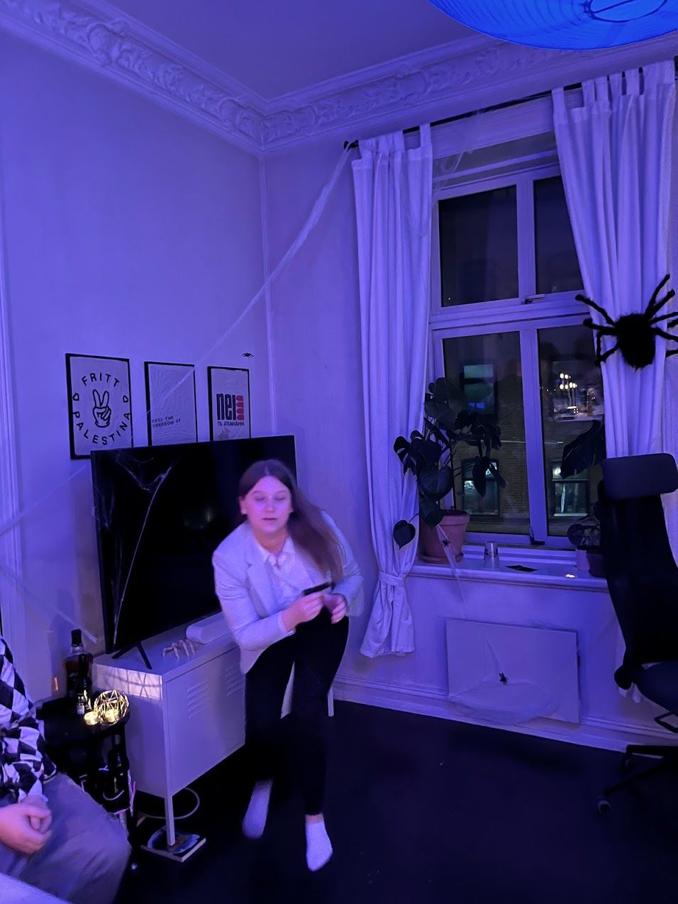 a girl playing a video game in a room with a peace sign on the wall