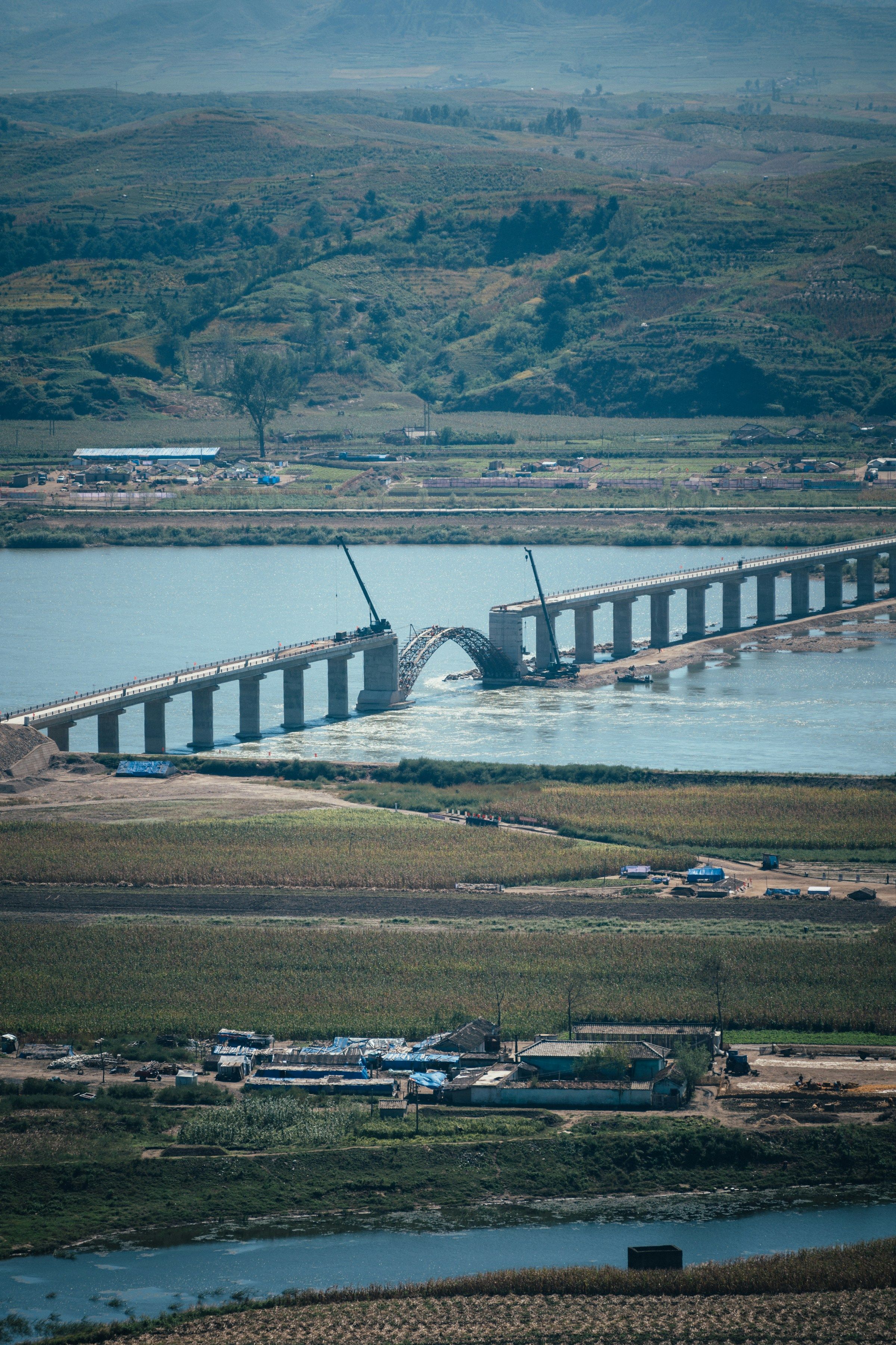 Two sections of an engineered bridge approaching an unfinished span
