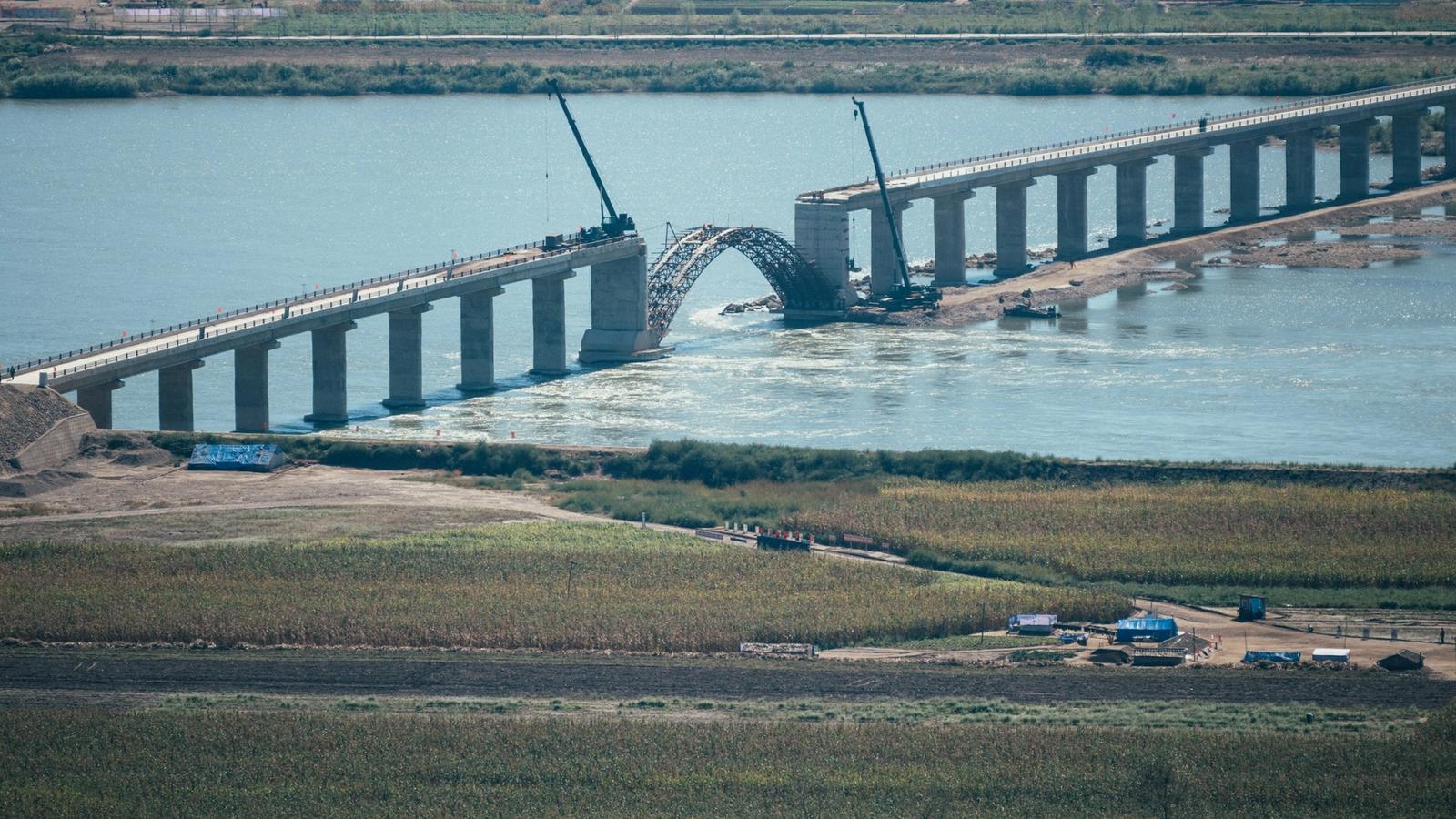 Two sections of an engineered bridge approaching an unfinished span